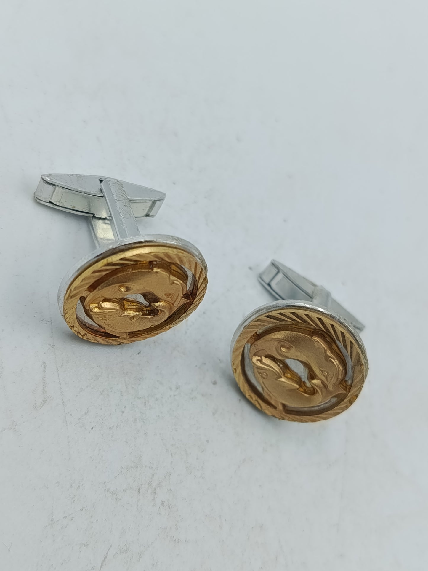 Goldfarbene Manschettenknöpfe mit Delfin Motiv und strukturierter Umrandung