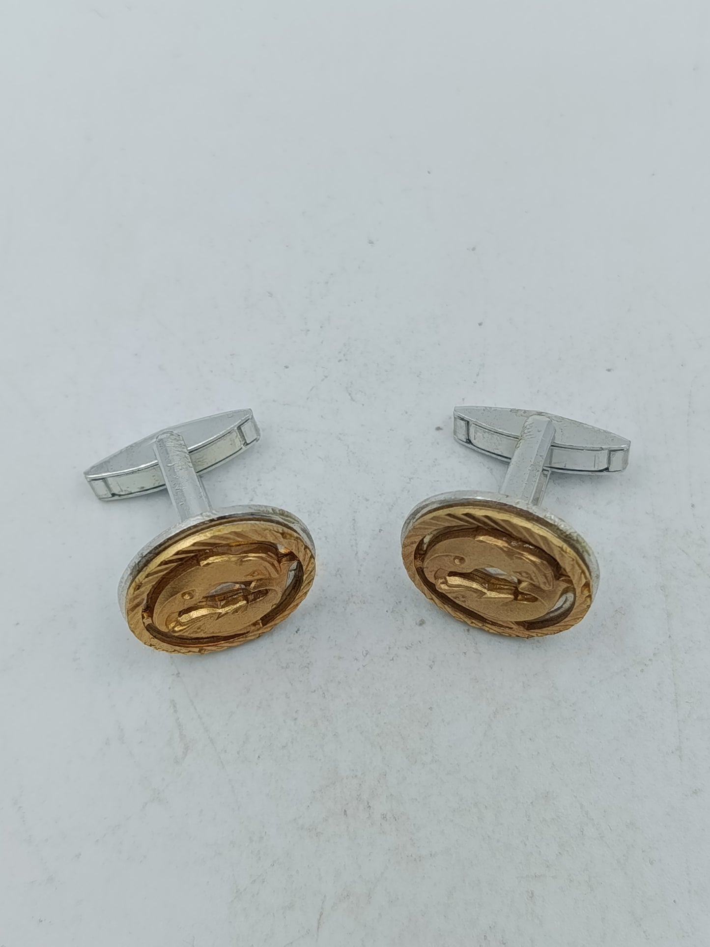 Goldfarbene Manschettenknöpfe mit Delfin Motiv und strukturierter Umrandung