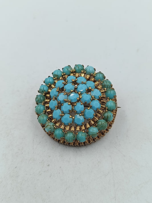 Runde Brosche in goldfarbener Optik mit türkisen Glassteinen im Vintage Stil