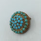 Runde Brosche in goldfarbener Optik mit türkisen Glassteinen im Vintage Stil