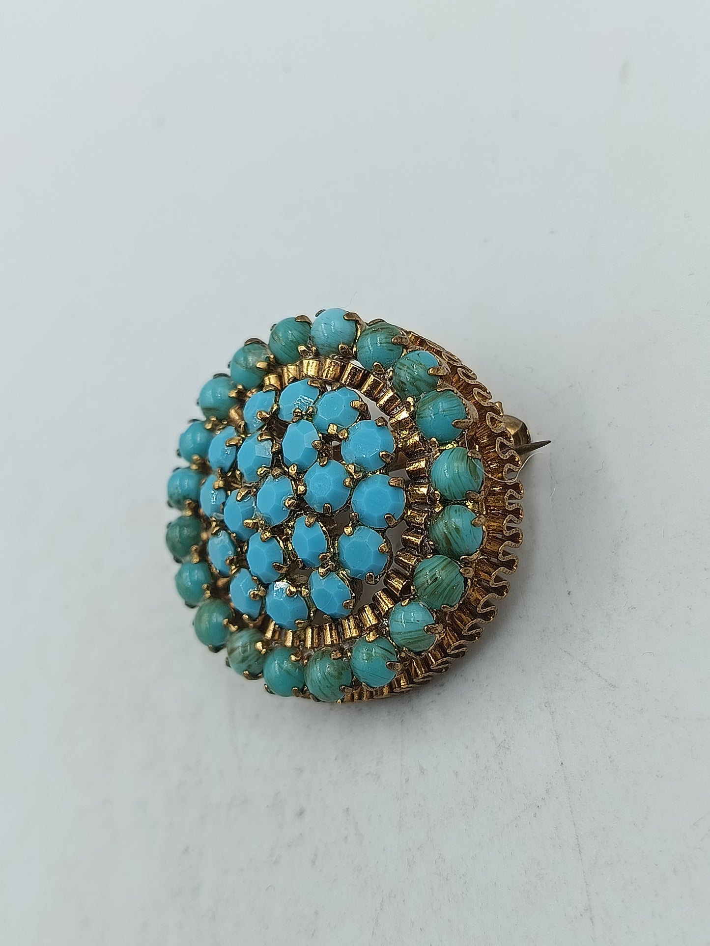 Runde Brosche in goldfarbener Optik mit türkisen Glassteinen im Vintage Stil