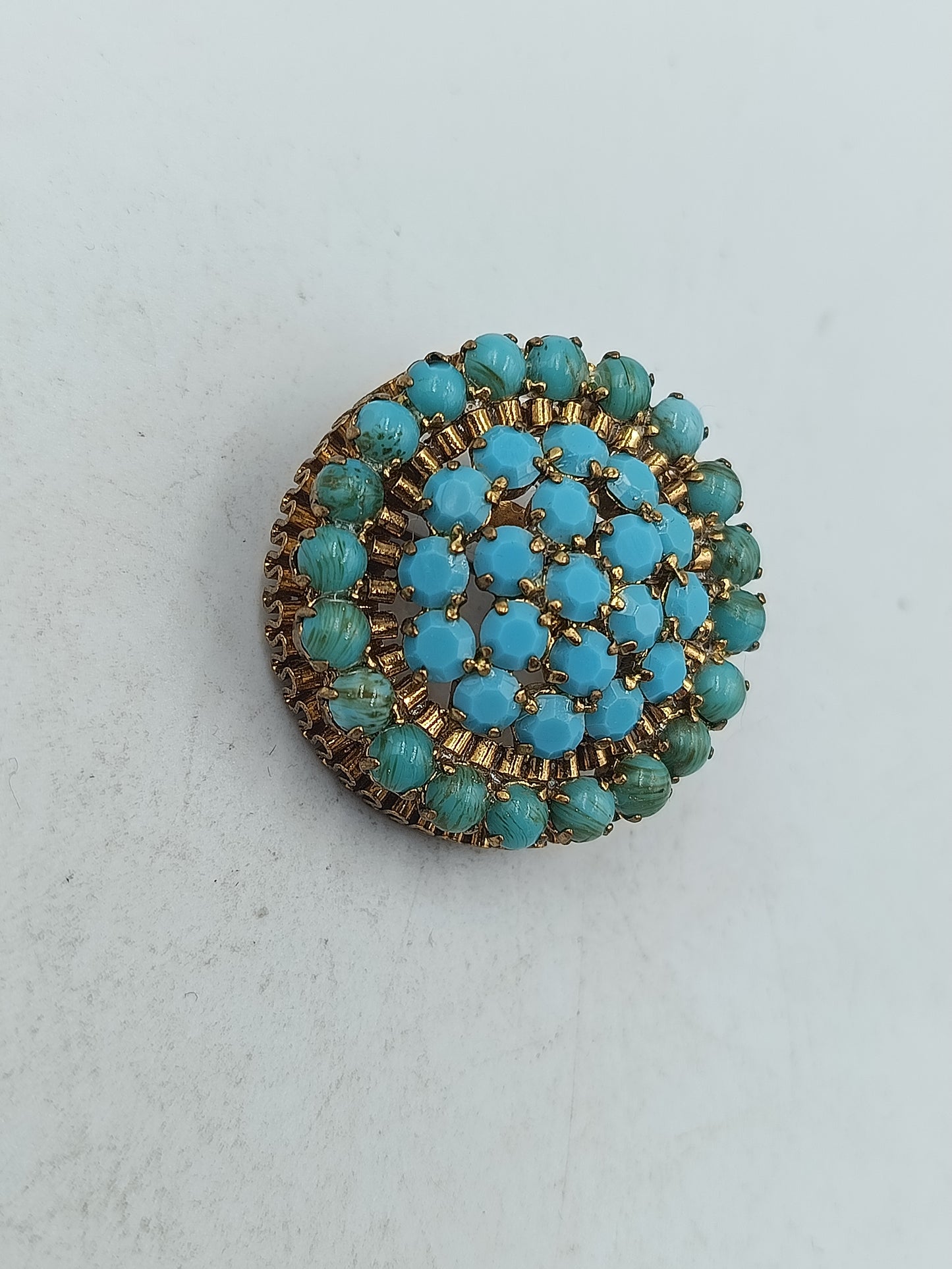 Runde Brosche in goldfarbener Optik mit türkisen Glassteinen im Vintage Stil