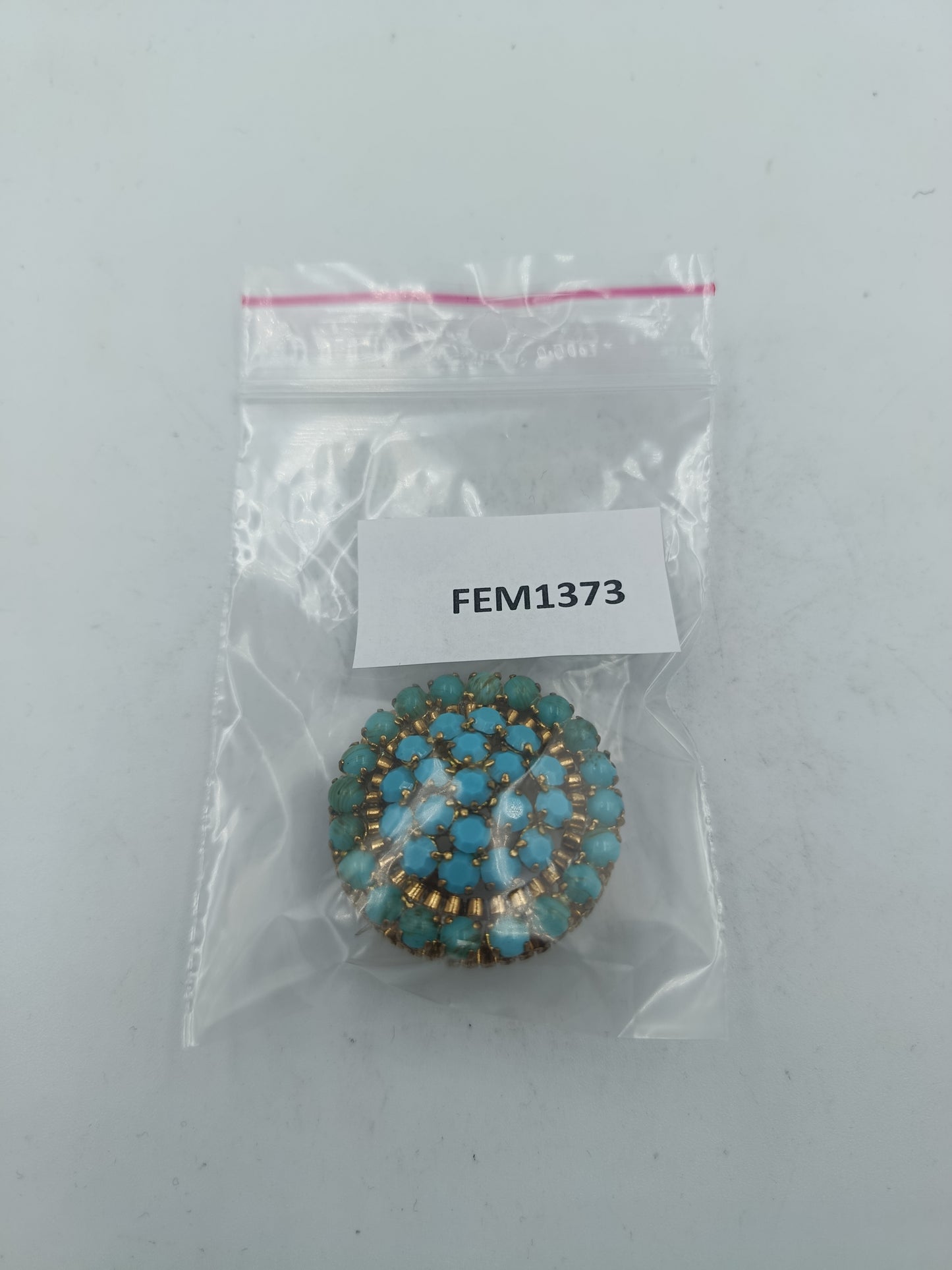 Runde Brosche in goldfarbener Optik mit türkisen Glassteinen im Vintage Stil