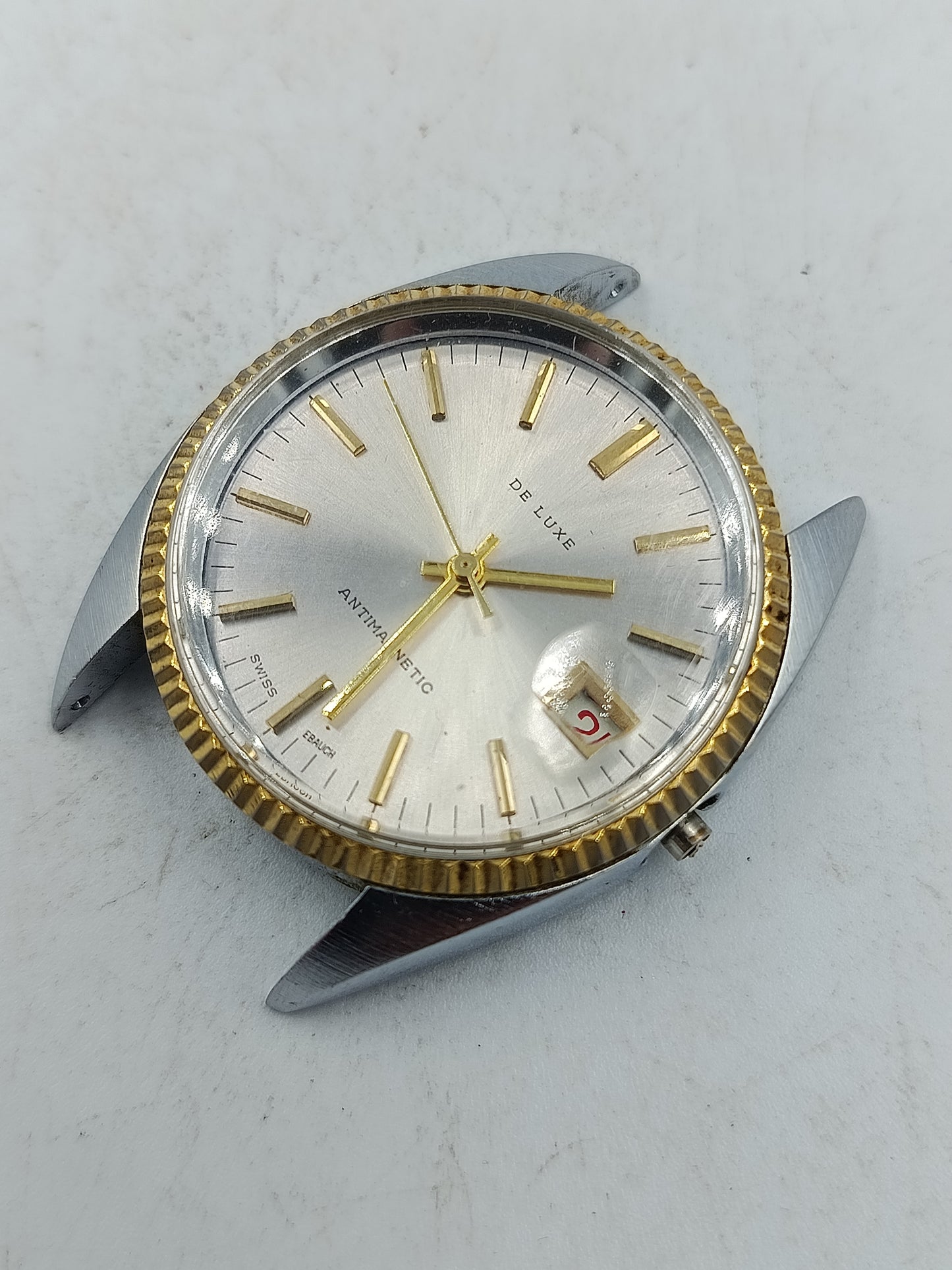 Klassische Schweizer Armbanduhr De Luxe mit goldfarbener Lünette