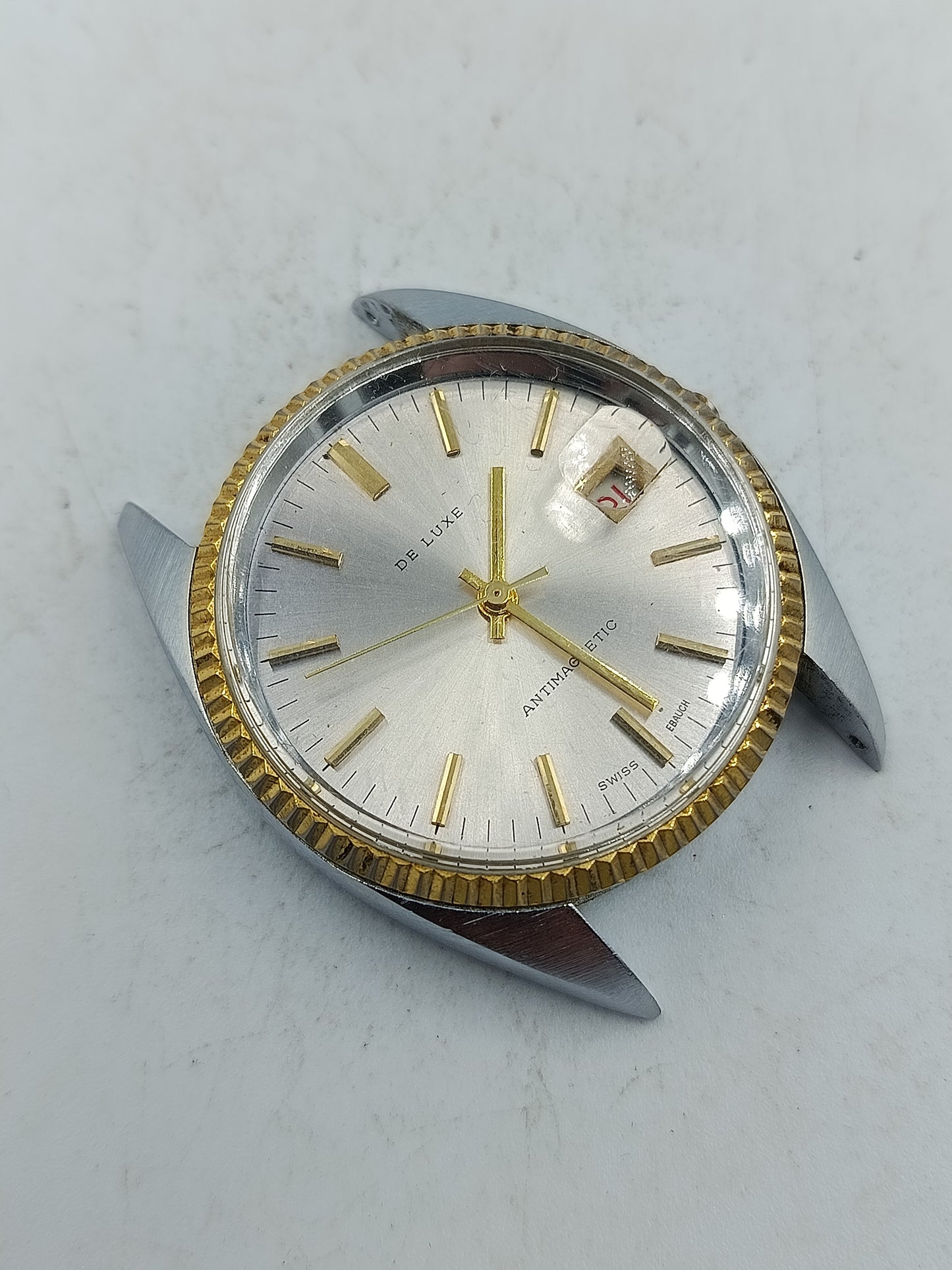 Klassische Schweizer Armbanduhr De Luxe mit goldfarbener Lünette