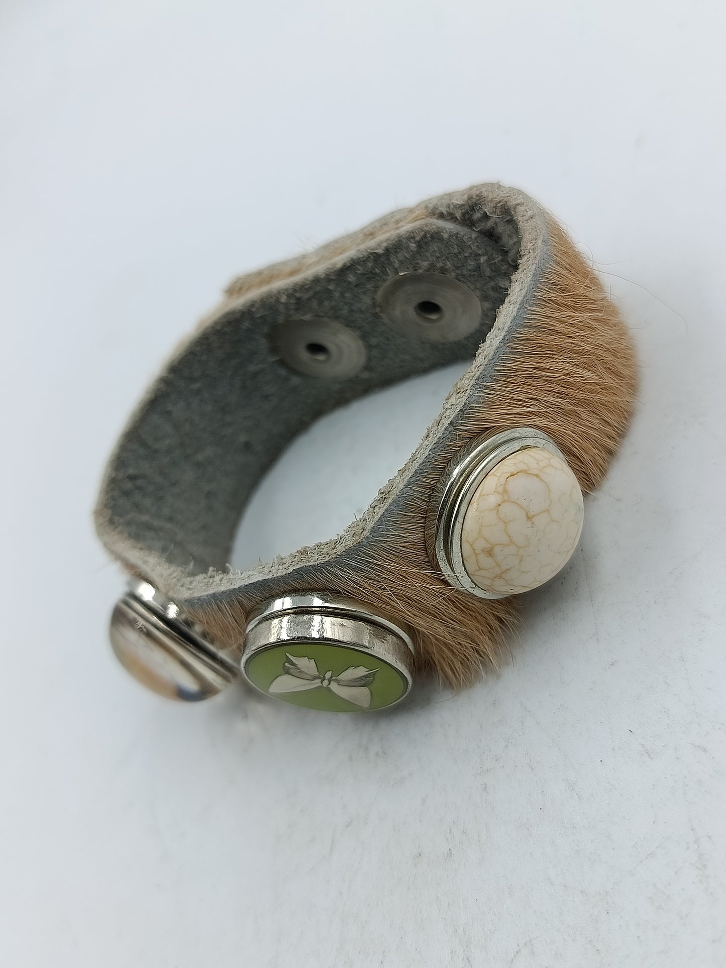 Armband aus Leder mit Felloptik und dekorativen Druckknöpfen im natürlichen Stil