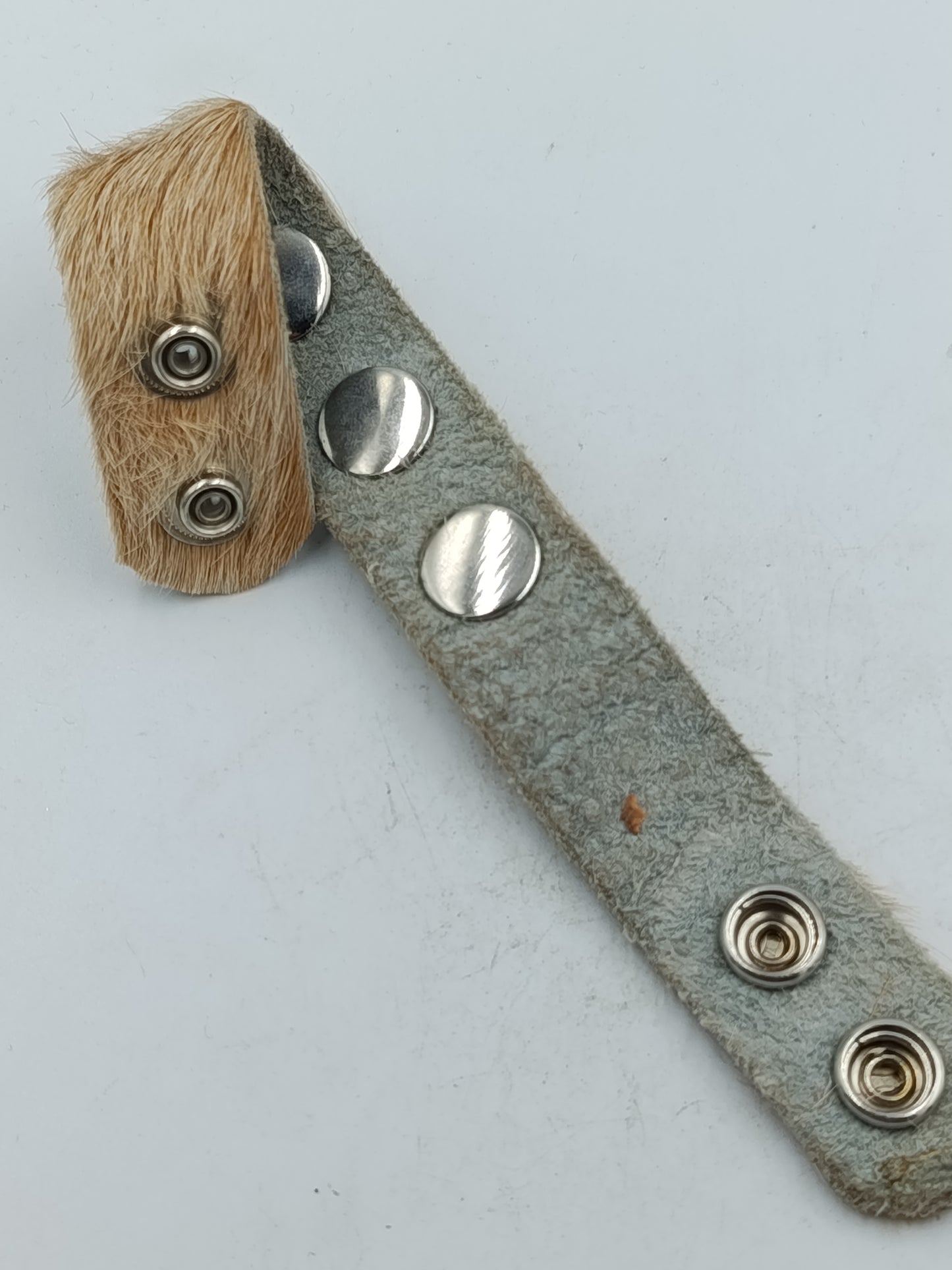 Armband aus Leder mit Felloptik und dekorativen Druckknöpfen im natürlichen Stil