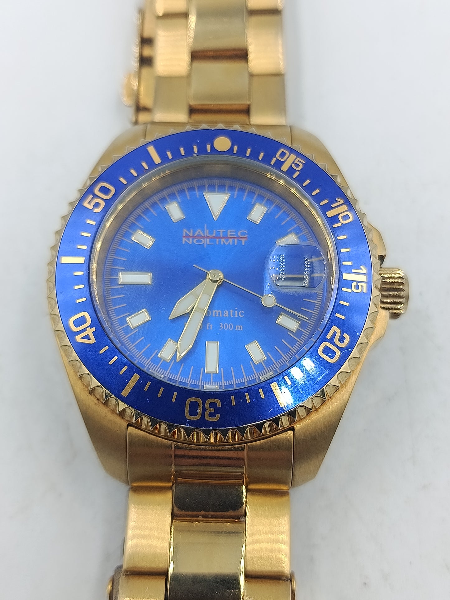 Goldfarbene Armbanduhr mit blauem Zifferblatt Metallarmband und Drehlünette