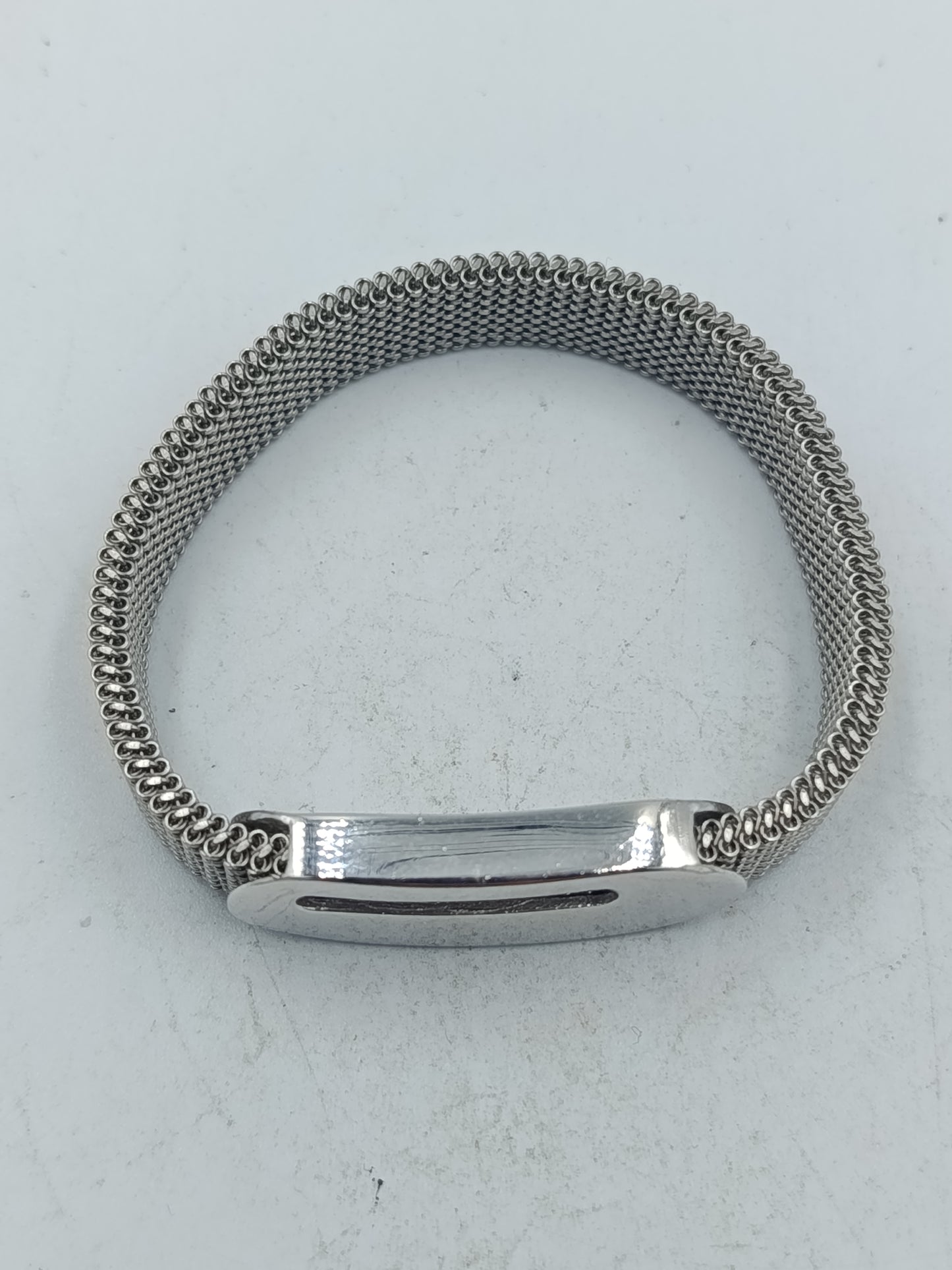 Silberfarbenes elastisches Armband mit feiner Metallstruktur und glattem Mittelstück