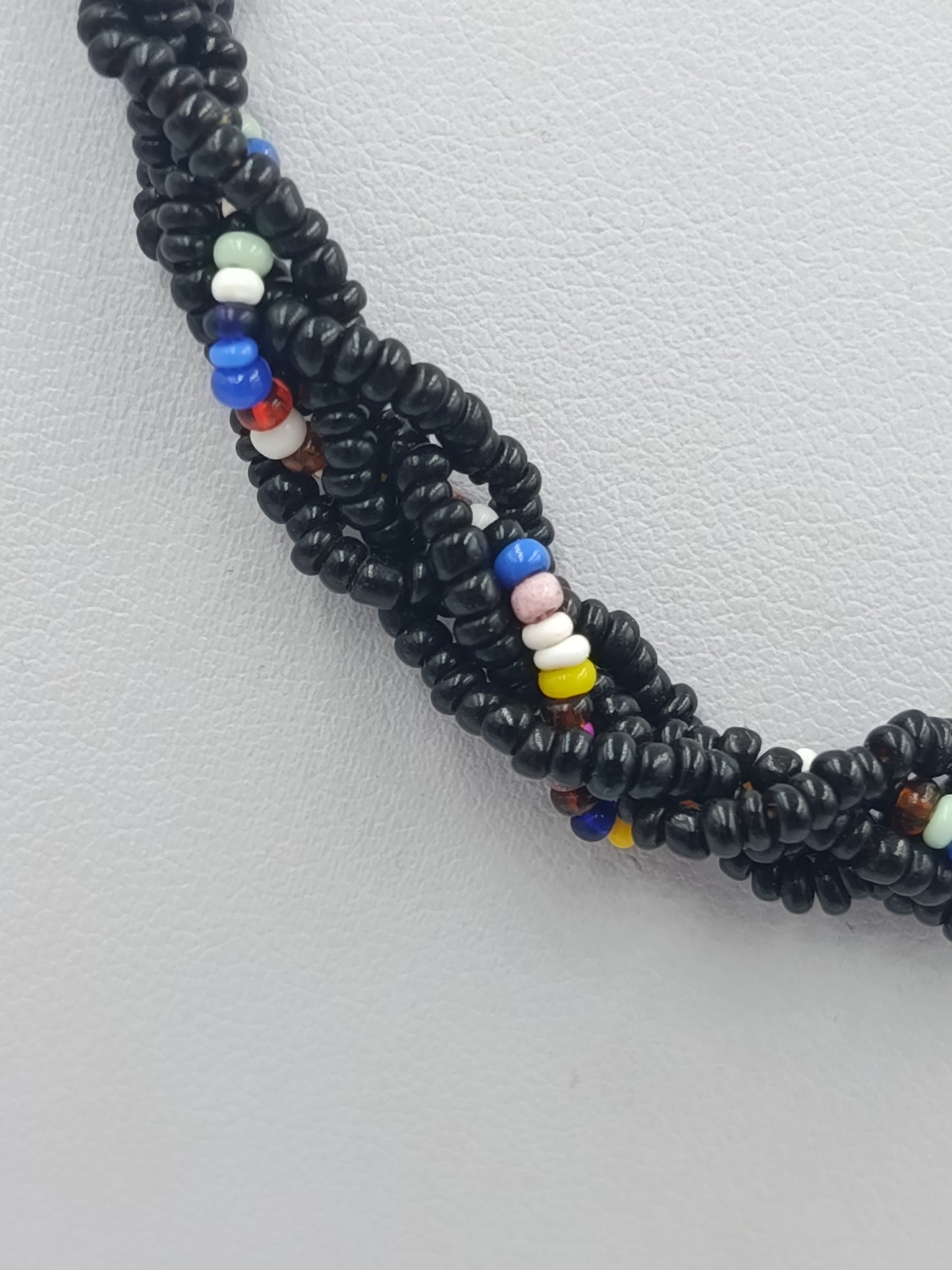 Bunte Glasperlenkette mit schwarzer Grundfarbe und dekorativem Mittelstein