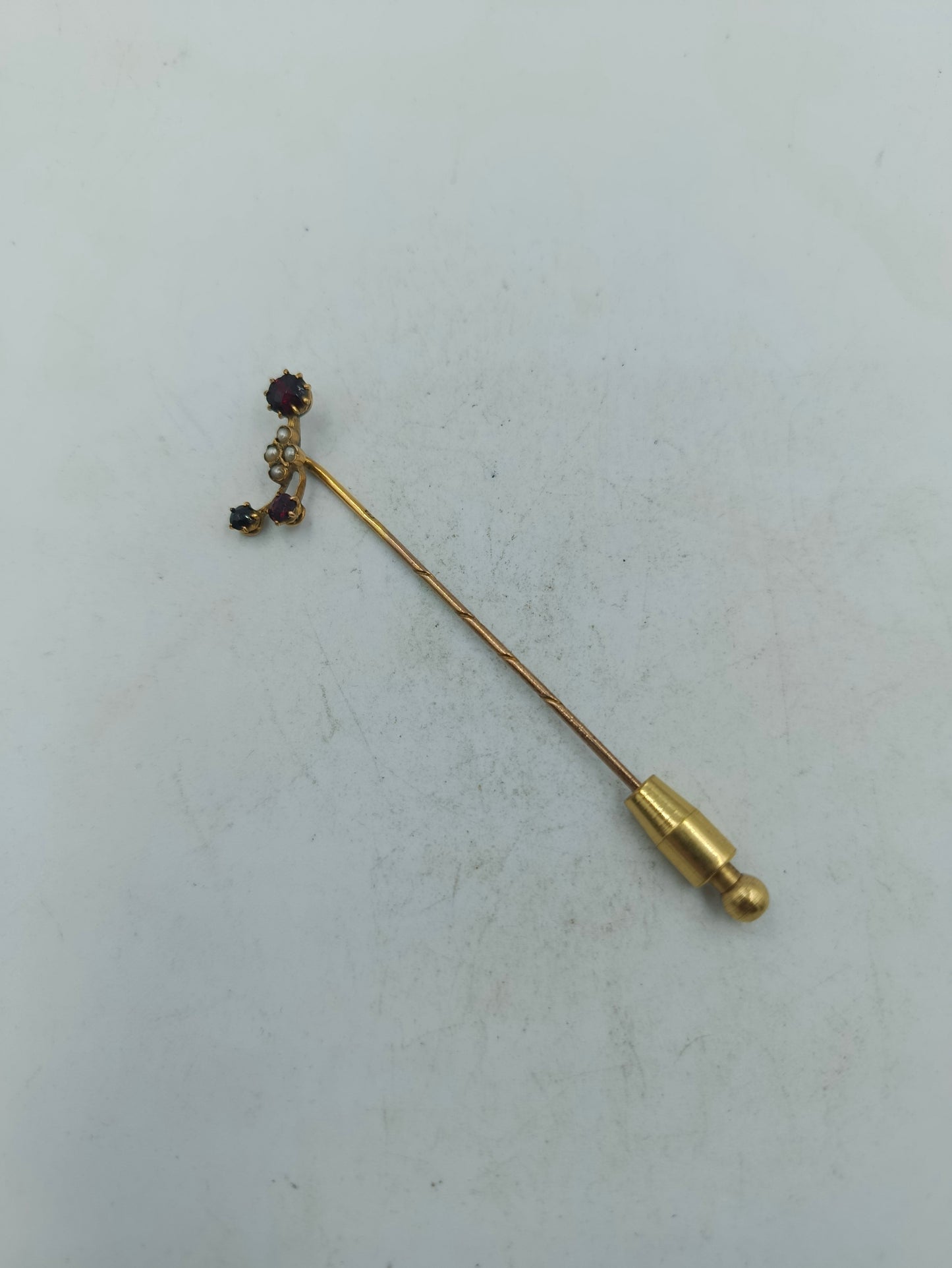 Elegante Anstecknadel mit rubinfarbenen Steinen und zarten Perlenakzenten