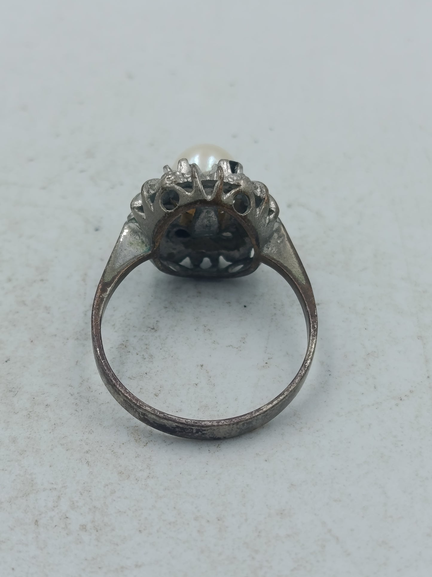 Perlenring mit dunkelblauen Steinen und kunstvoller silberfarbener Fassung im klassischen Stil