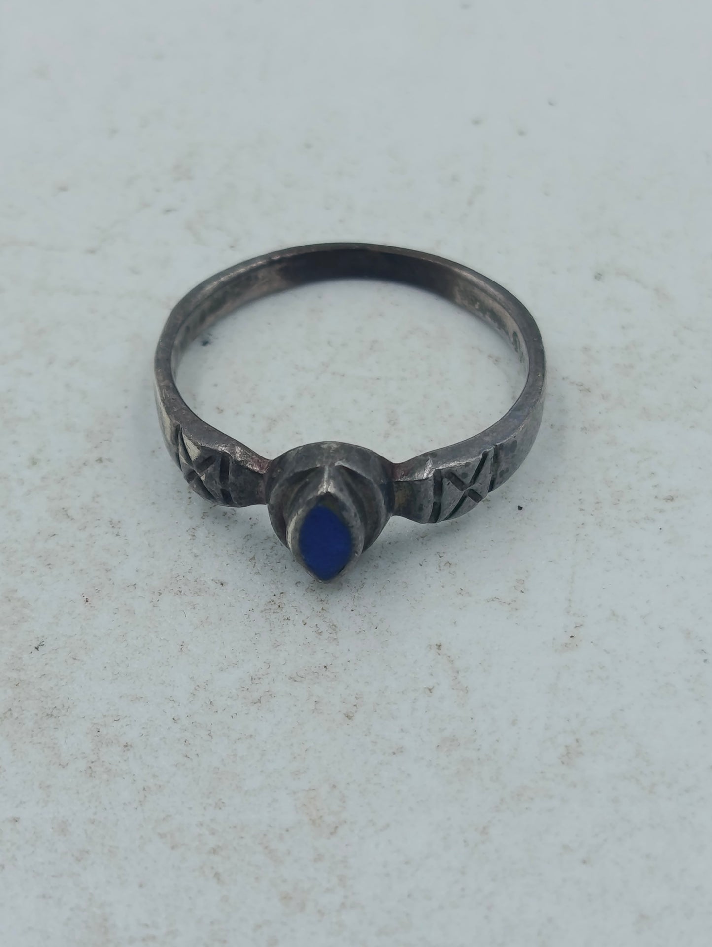 Schmaler Silberring mit tiefblauem Stein und kunstvoller Gravur im klassischen Design