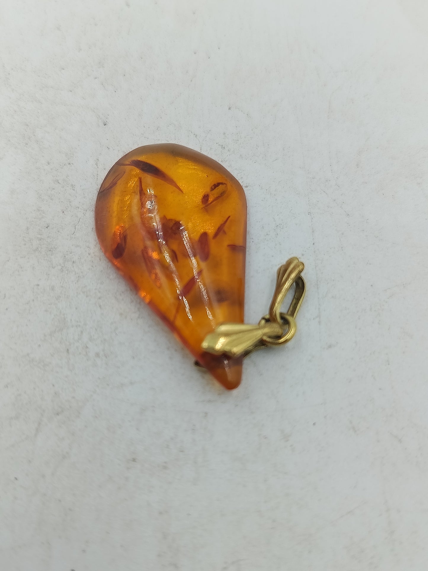 Bernsteinanhaenger in Tropfenform mit warmem Honigton und eleganter goldfarbener Oese