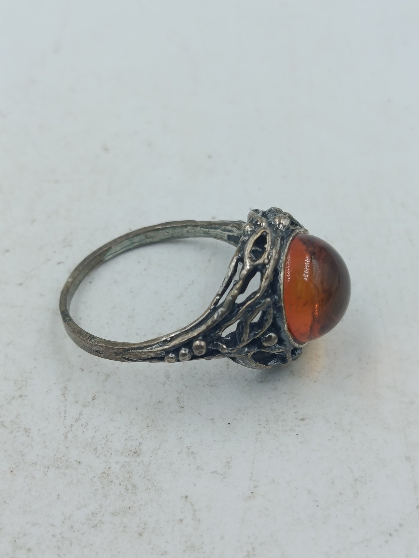 Ring mit bernsteinfarbenem Stein und kunstvoll durchbrochener Silberoptik im klassischen Design