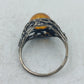 Ring mit bernsteinfarbenem Stein und kunstvoll durchbrochener Silberoptik im klassischen Design