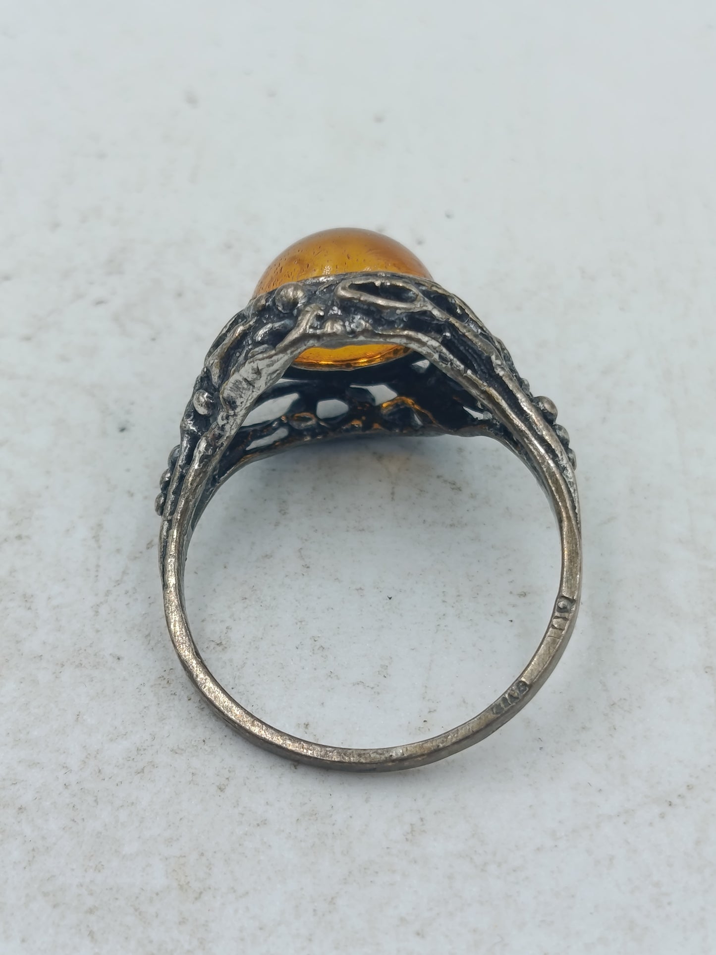 Ring mit bernsteinfarbenem Stein und kunstvoll durchbrochener Silberoptik im klassischen Design