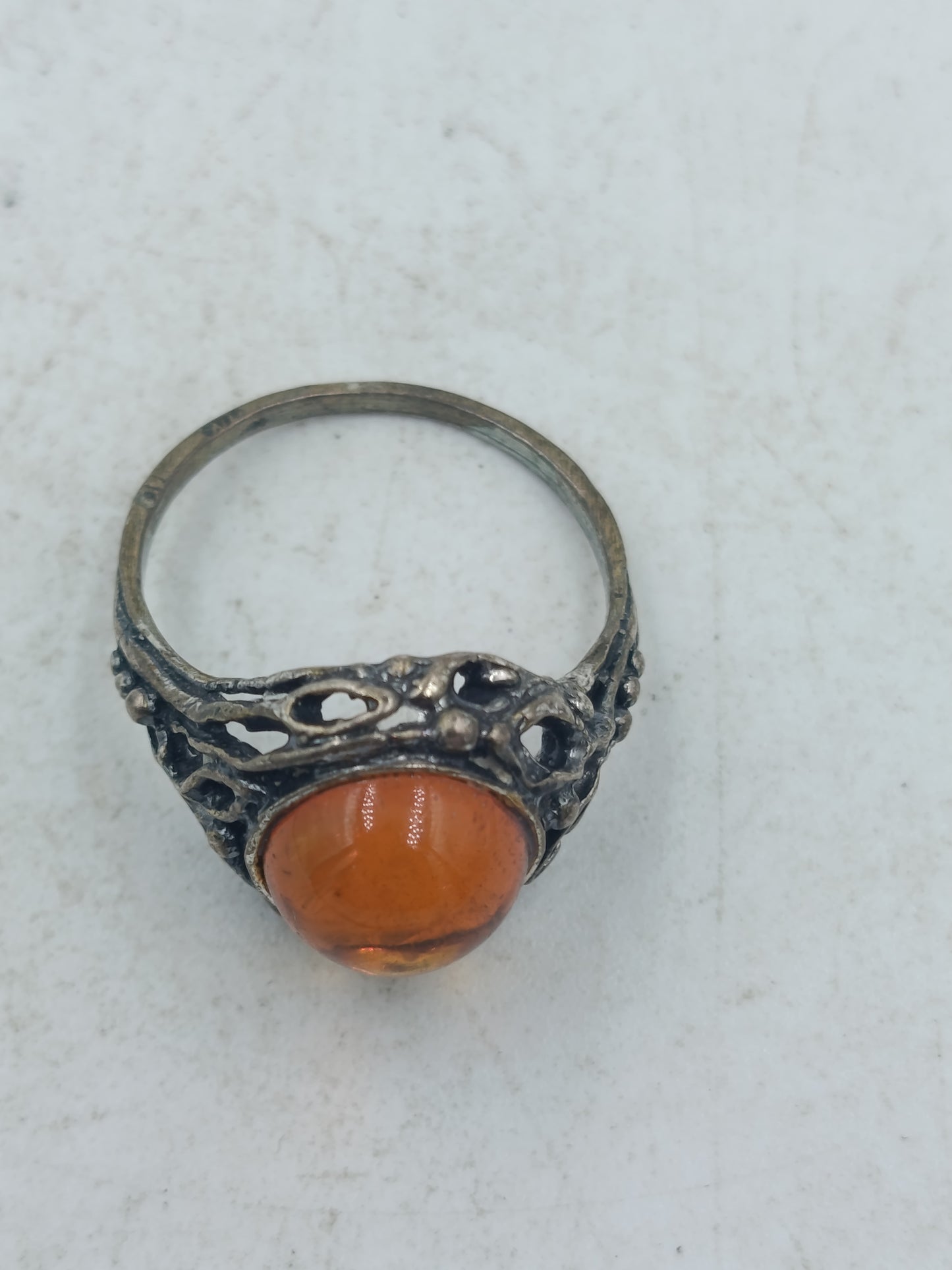 Ring mit bernsteinfarbenem Stein und kunstvoll durchbrochener Silberoptik im klassischen Design