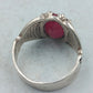 Silberring mit grossem rubinfarbenem Stein und kunstvoll verzierten Seitenflaechen im edlen Stil