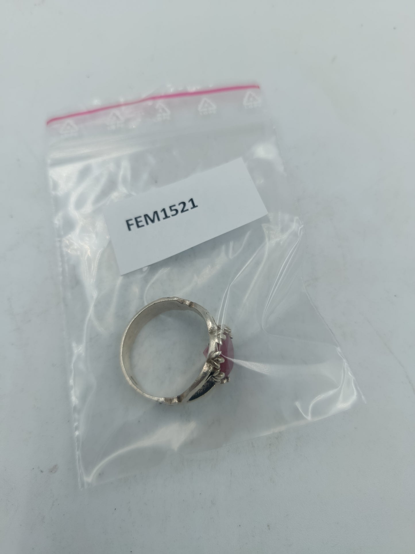 Silberring mit grossem rubinfarbenem Stein und kunstvoll verzierten Seitenflaechen im edlen Stil