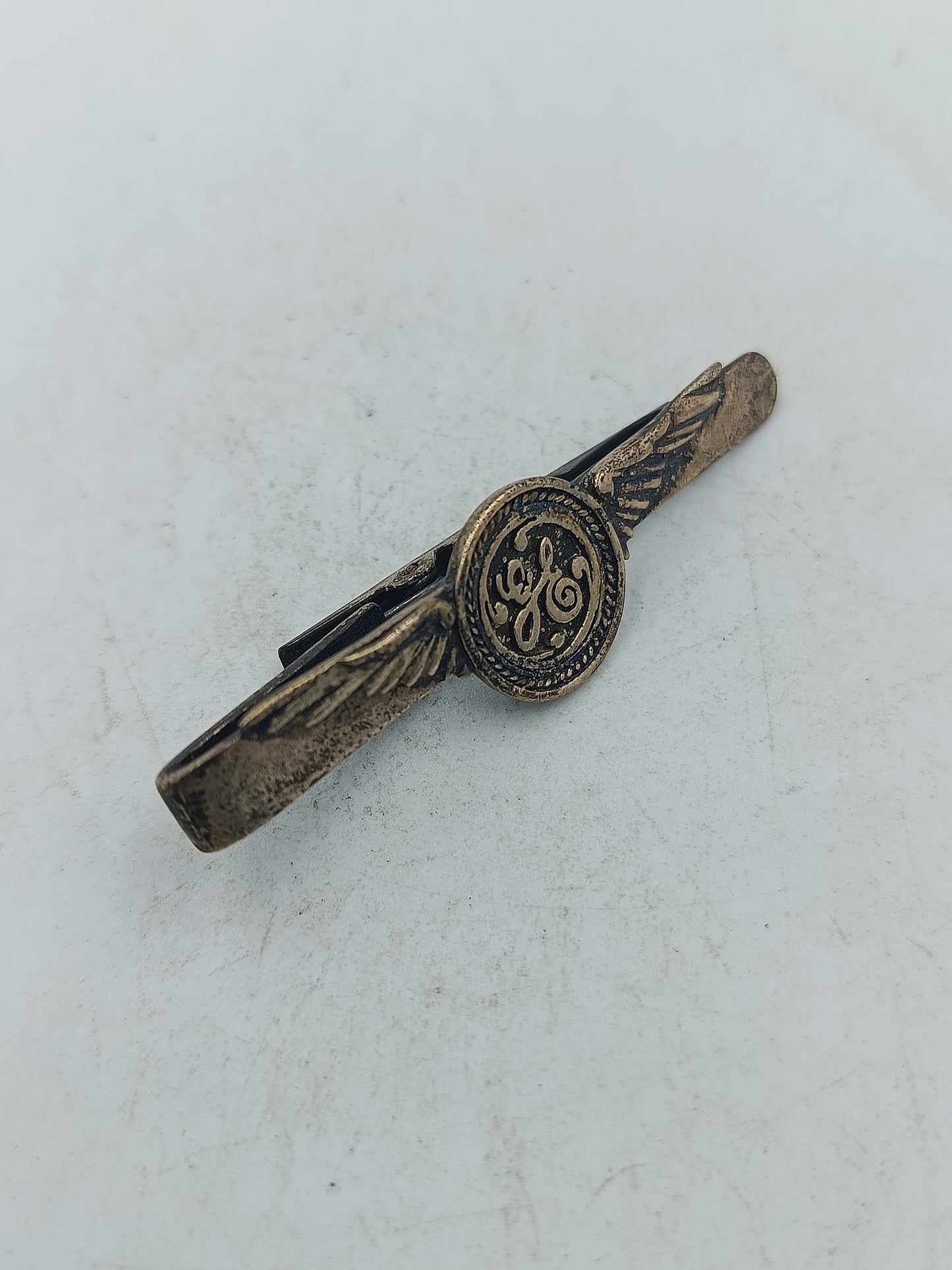 Vintage Krawattennadel mit GE-Monogramm und Flügelmotiv