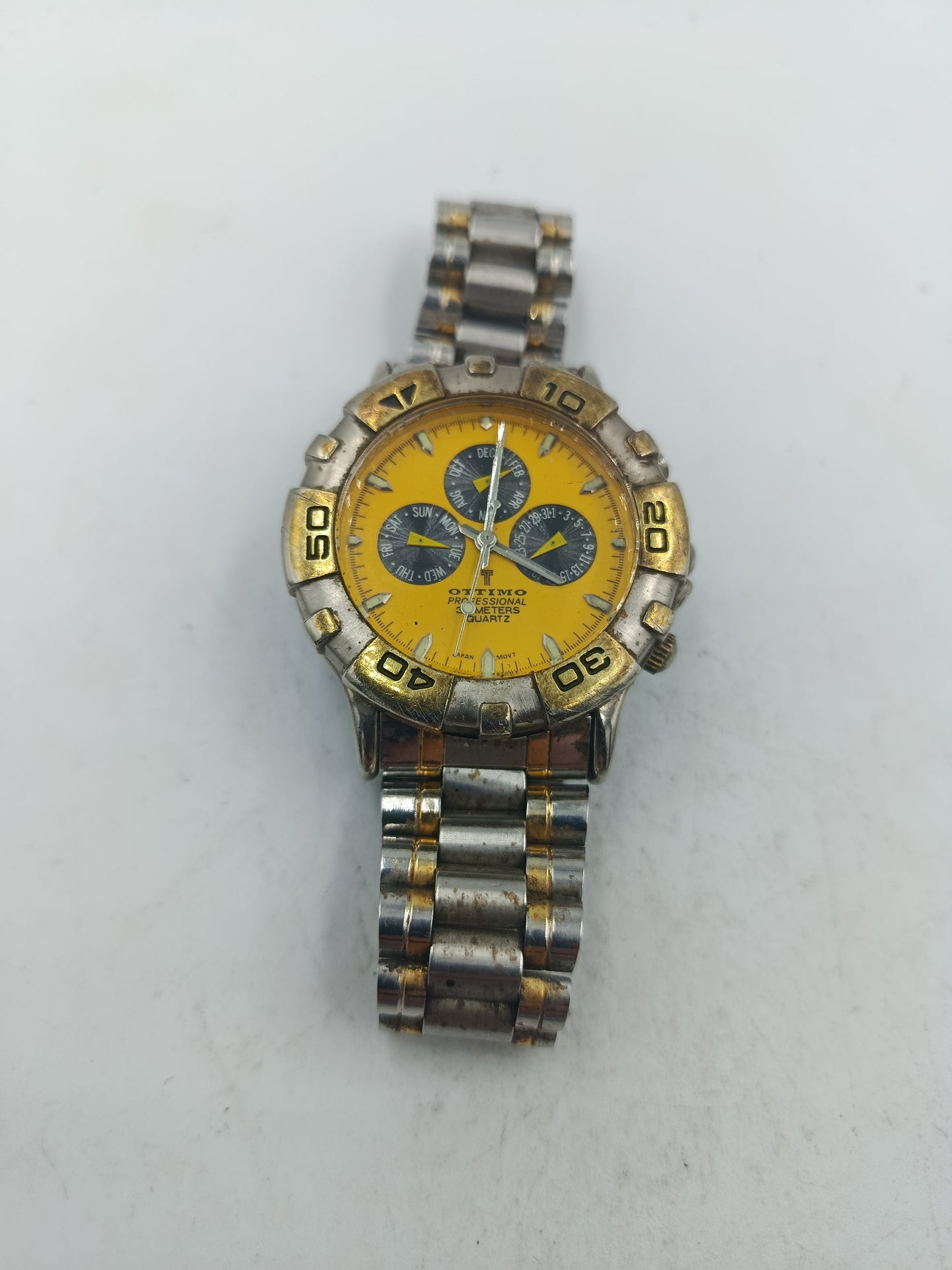 Sportliche Armbanduhr mit gelbem Zifferblatt und massivem Metallarmband im markanten Stil