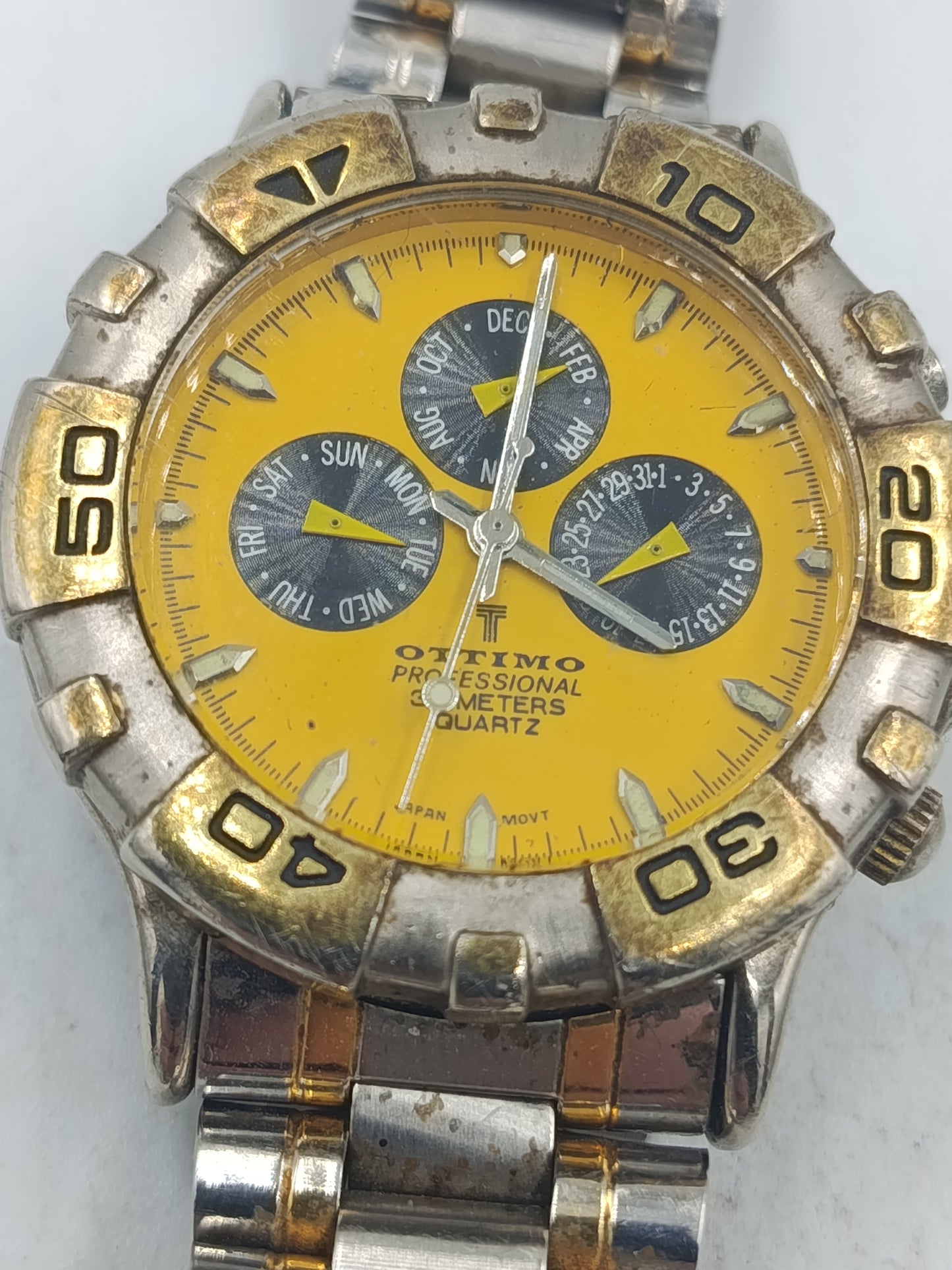 Sportliche Armbanduhr mit gelbem Zifferblatt und massivem Metallarmband im markanten Stil