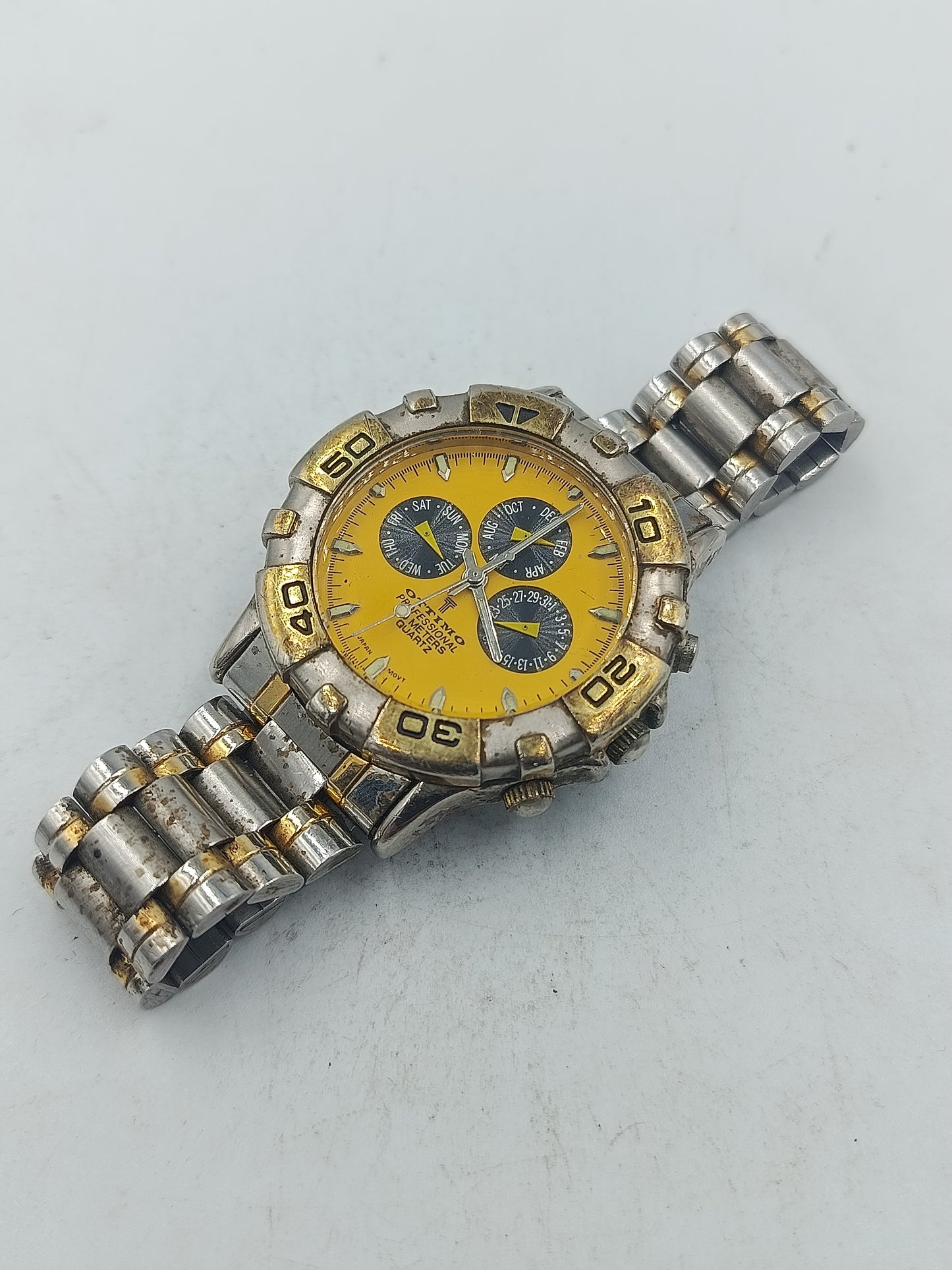 Sportliche Armbanduhr mit gelbem Zifferblatt und massivem Metallarmband im markanten Stil