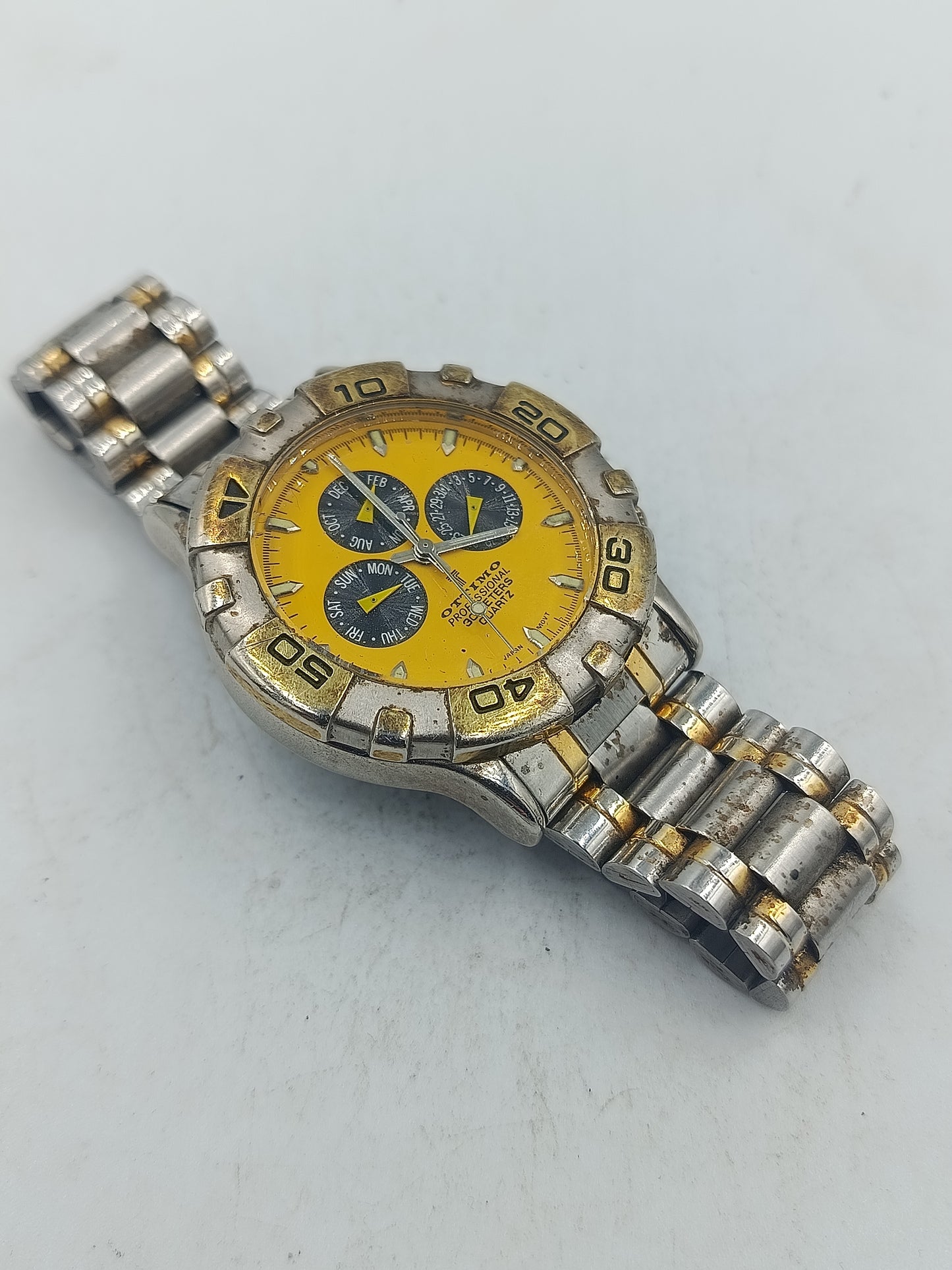 Sportliche Armbanduhr mit gelbem Zifferblatt und massivem Metallarmband im markanten Stil