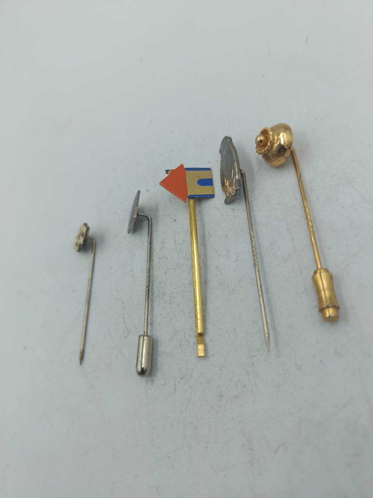 Vintage Set aus fünf Anstecknadeln mit unterschiedlichen Motiven und Metalloberflächen