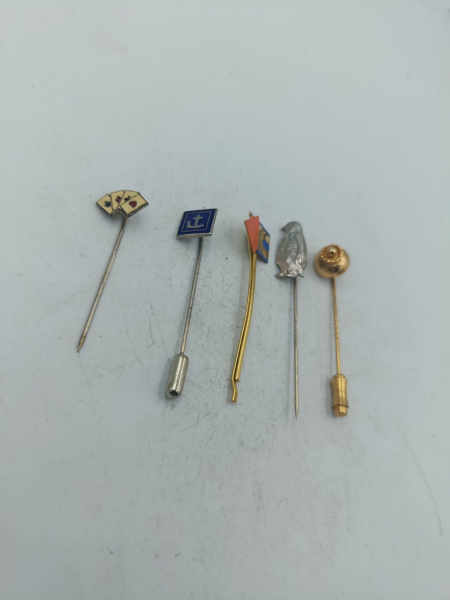 Vintage Set aus fünf Anstecknadeln mit unterschiedlichen Motiven und Metalloberflächen