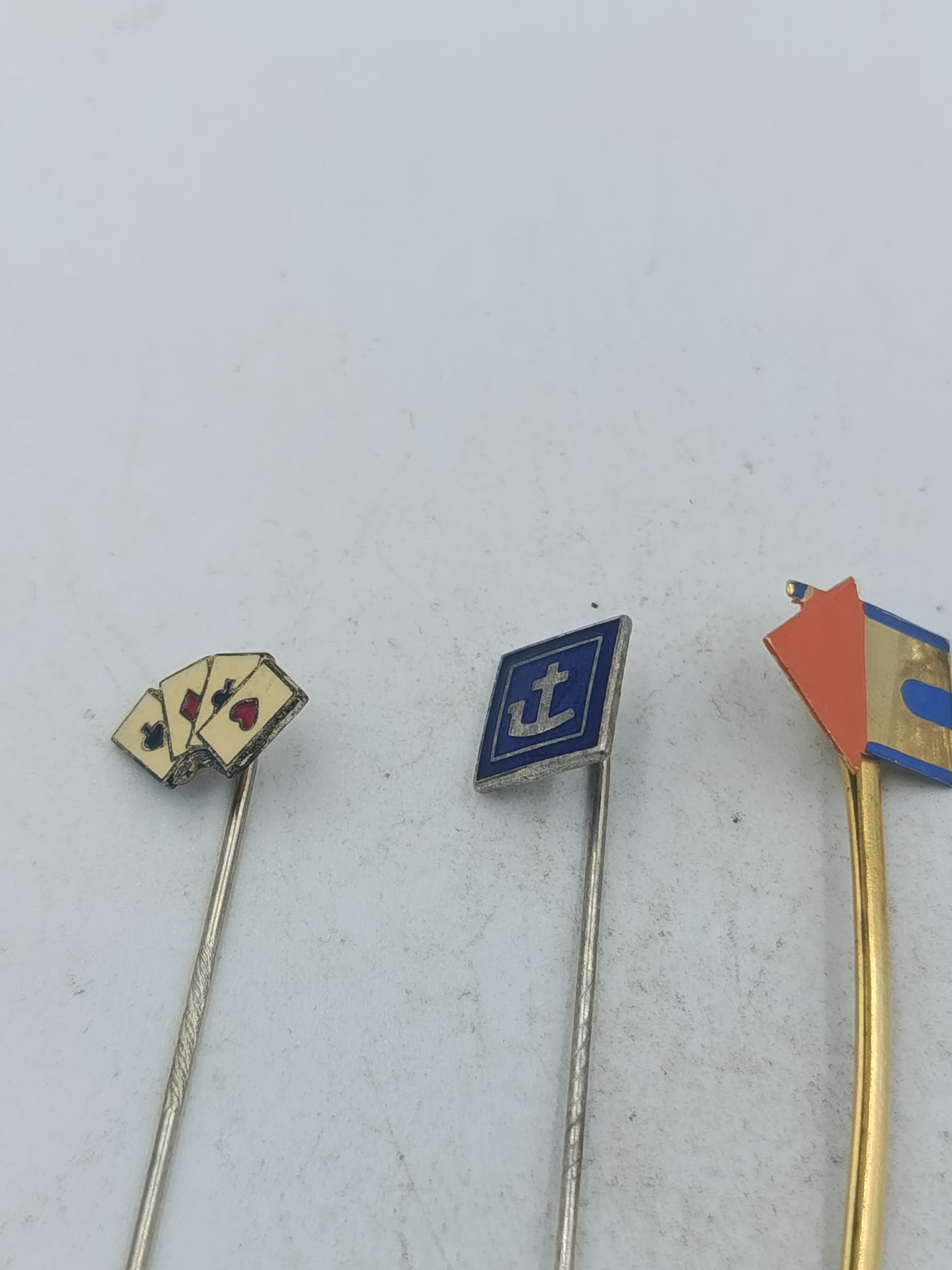 Vintage Set aus fünf Anstecknadeln mit unterschiedlichen Motiven und Metalloberflächen