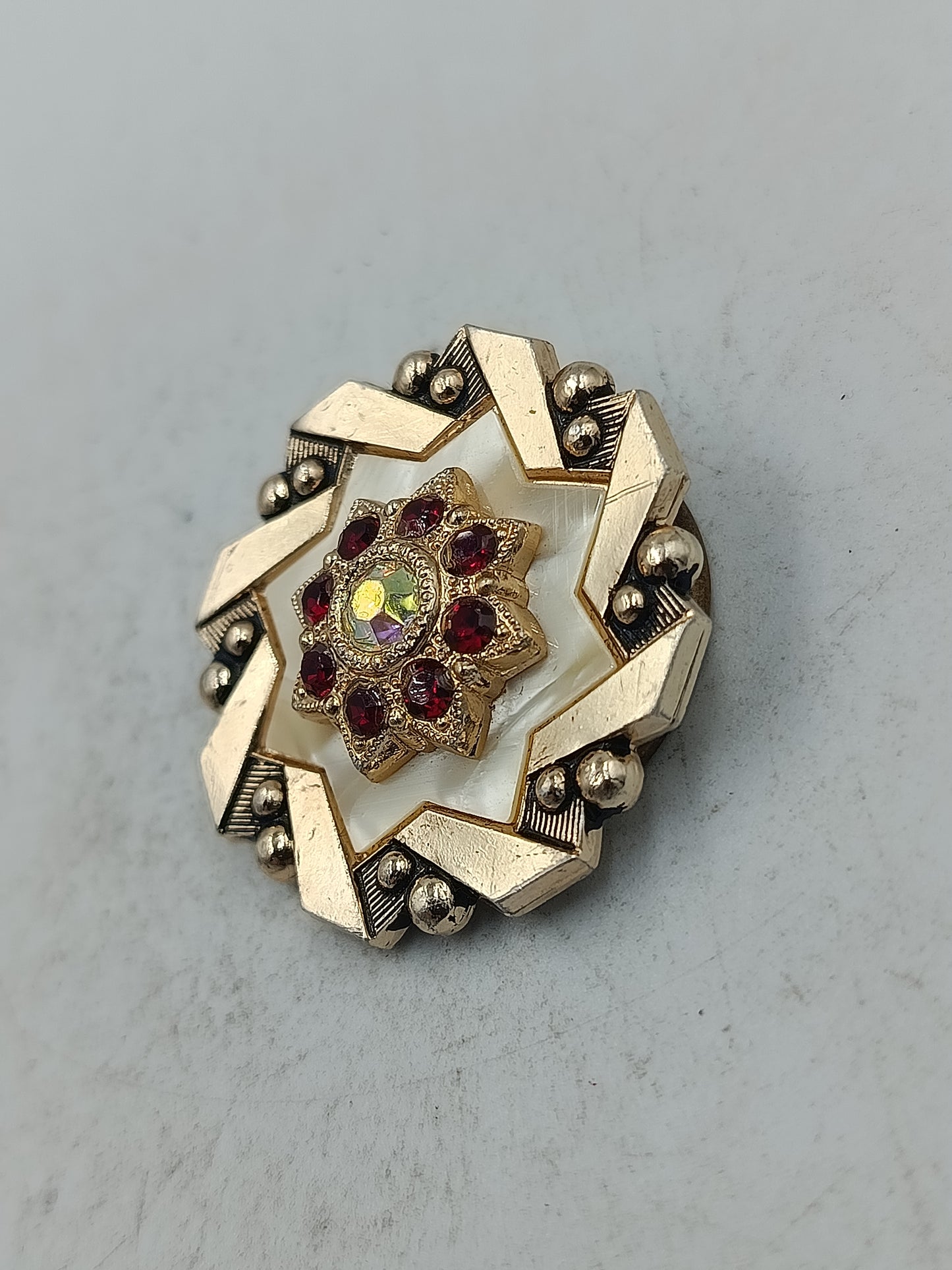 Cilpper in Goldoptik mit rotem Steindesign und   Akzent für ausdrucksstarke Eleganz