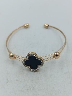 Elegantes Armreif Armband in Goldoptik mit schwarzem Kleeblatt