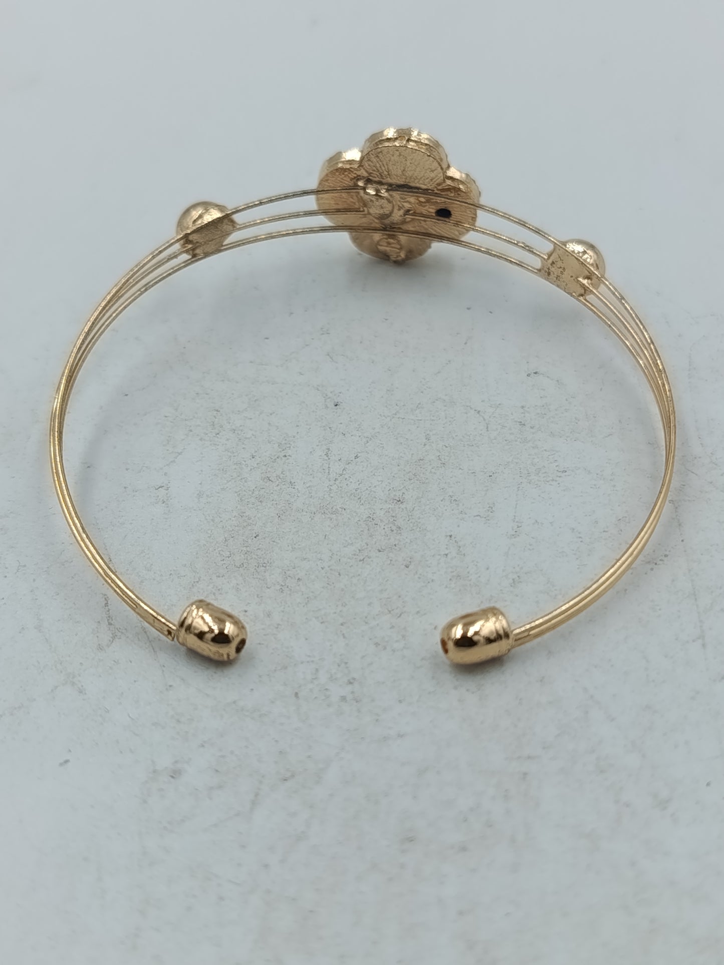 Elegantes Armreif Armband in Goldoptik mit schwarzem Kleeblatt und funkelndem Strassbesatz