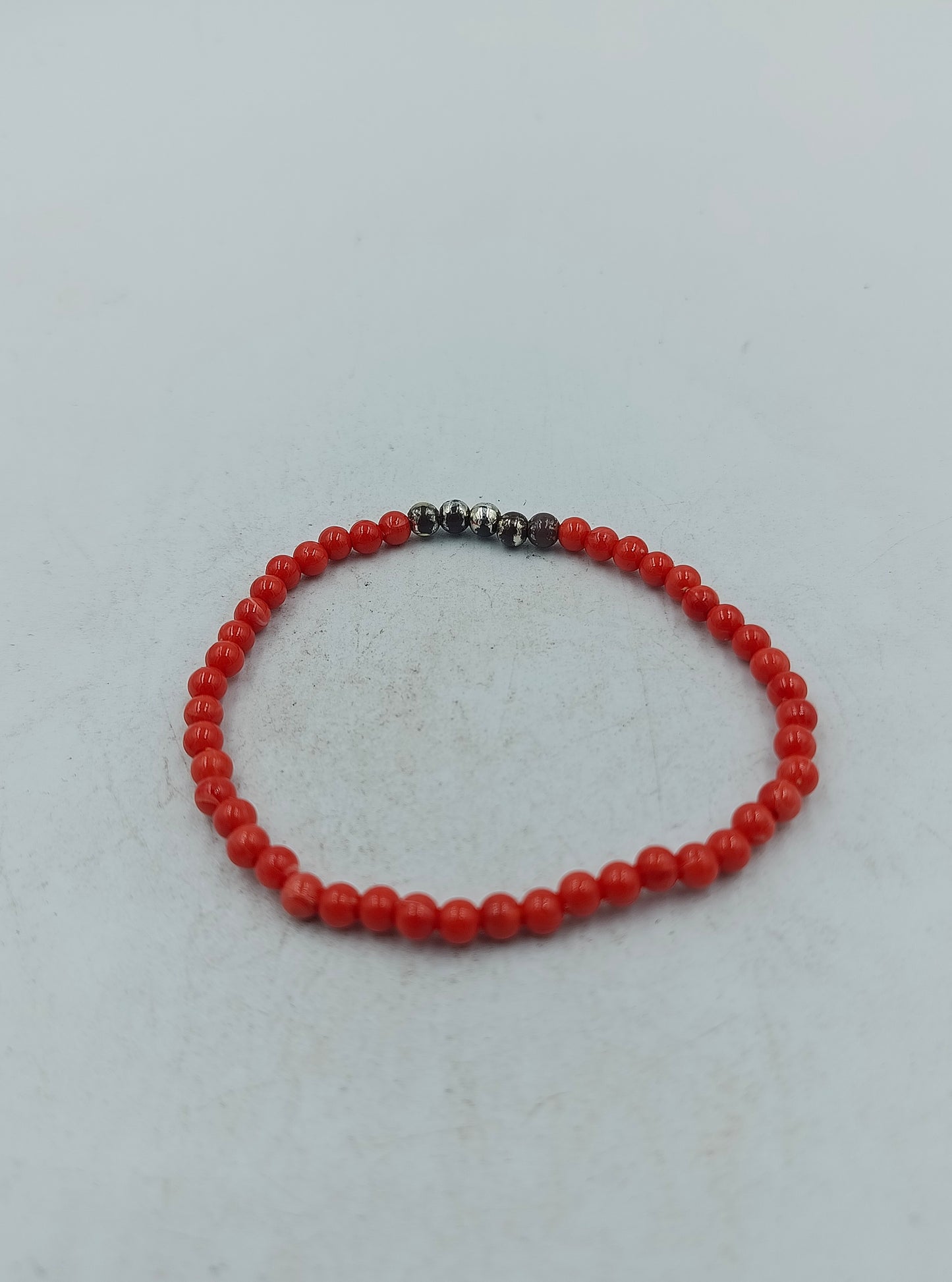 Feines elastisches Perlenarmband in kräftigem Rot mit dezenten dunklen Akzentperlen