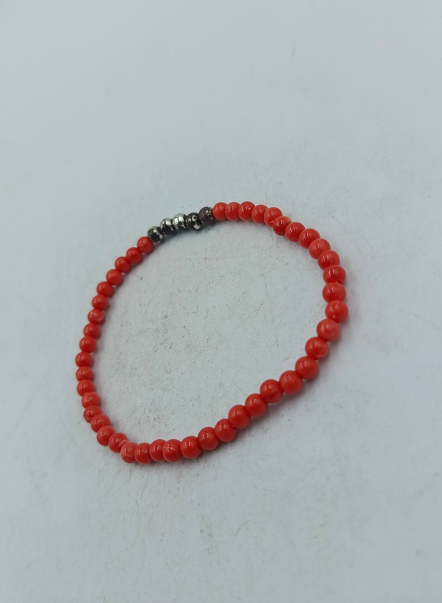 Feines elastisches Perlenarmband in kräftigem Rot mit dezenten dunklen Akzentperlen