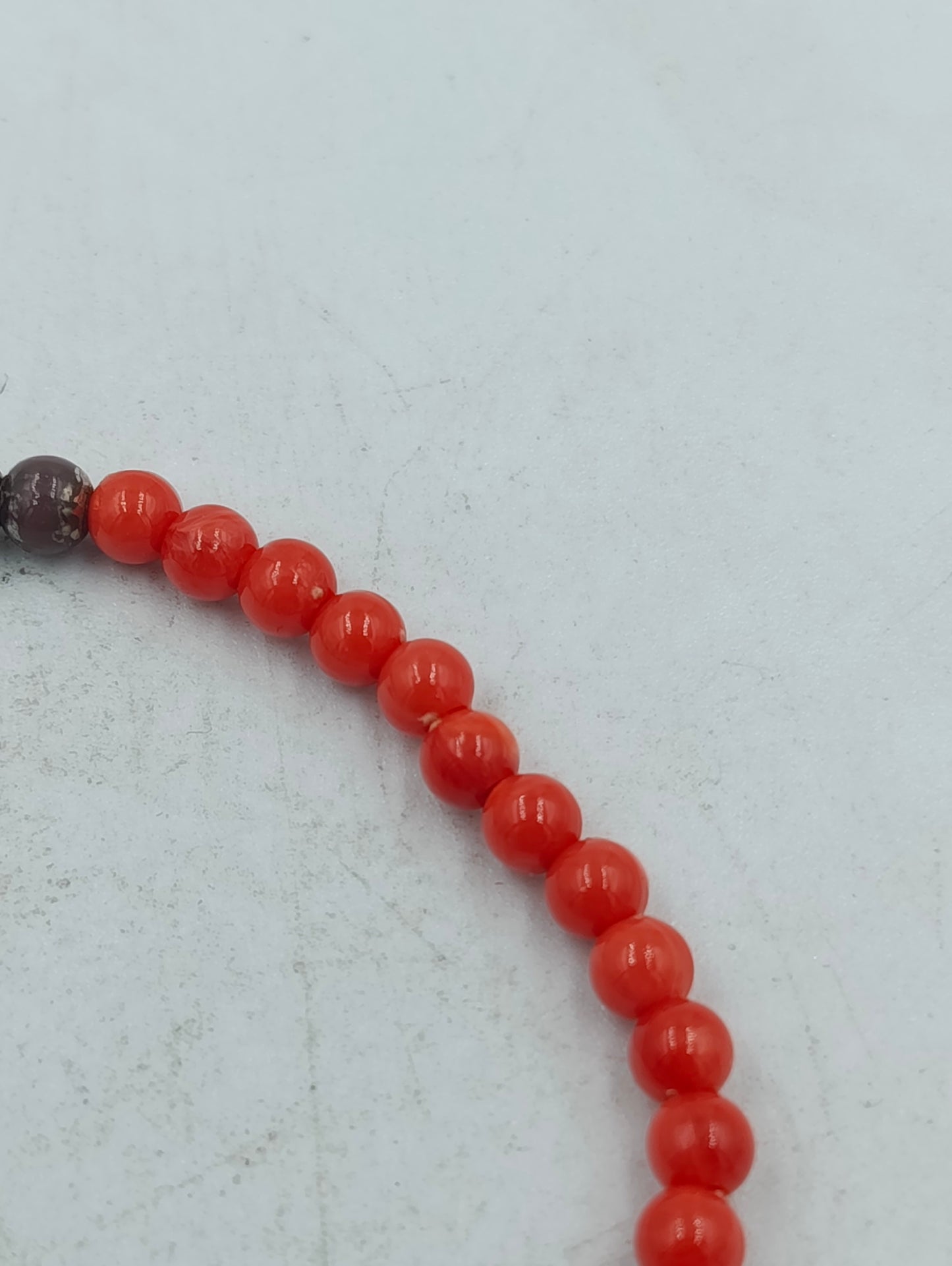 Feines elastisches Perlenarmband in kräftigem Rot mit dezenten dunklen Akzentperlen