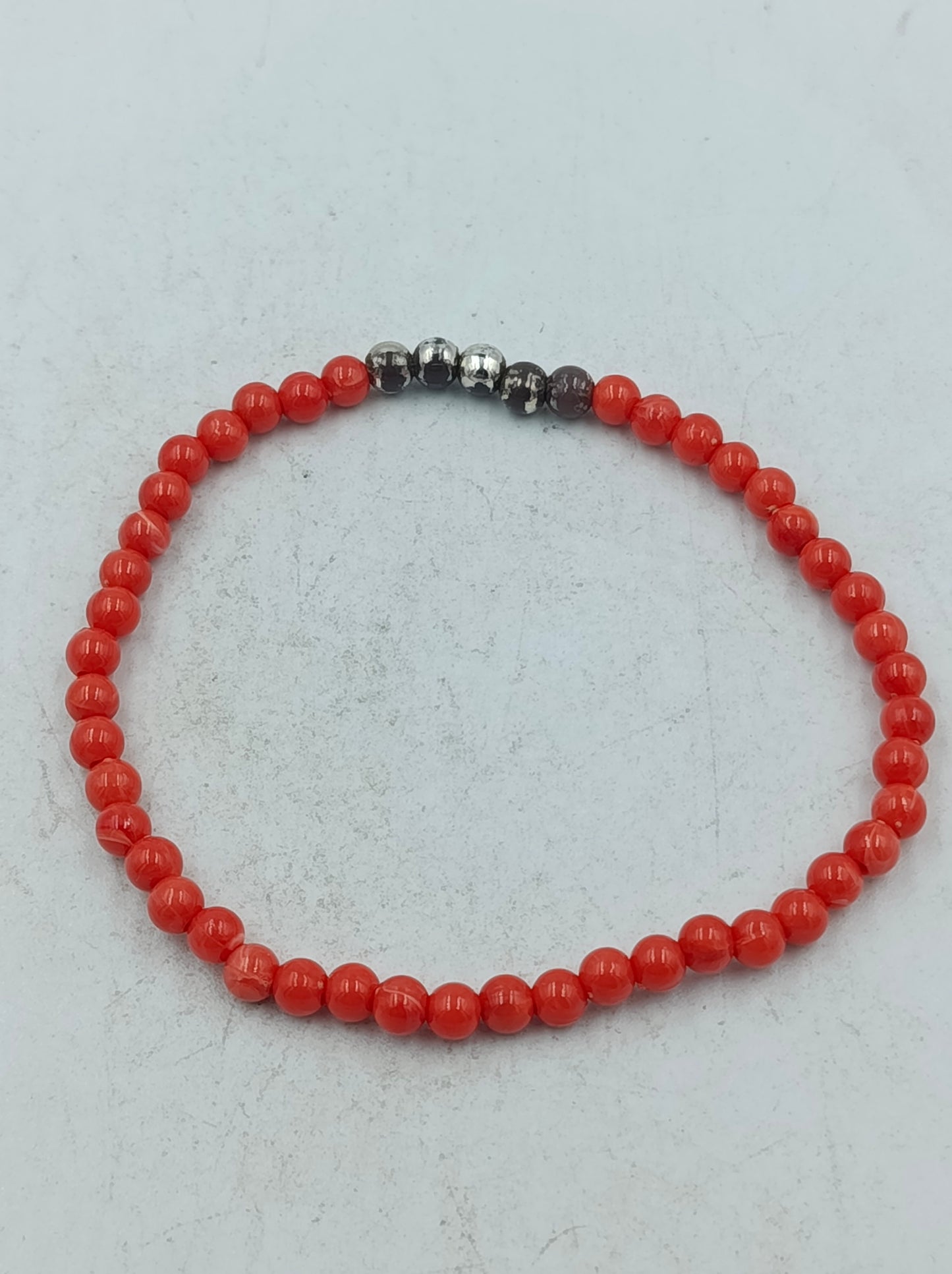 Feines elastisches Perlenarmband in kräftigem Rot mit dezenten dunklen Akzentperlen