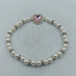 Elegantes elastisches Perlenarmband mit Herz-Zierelement
