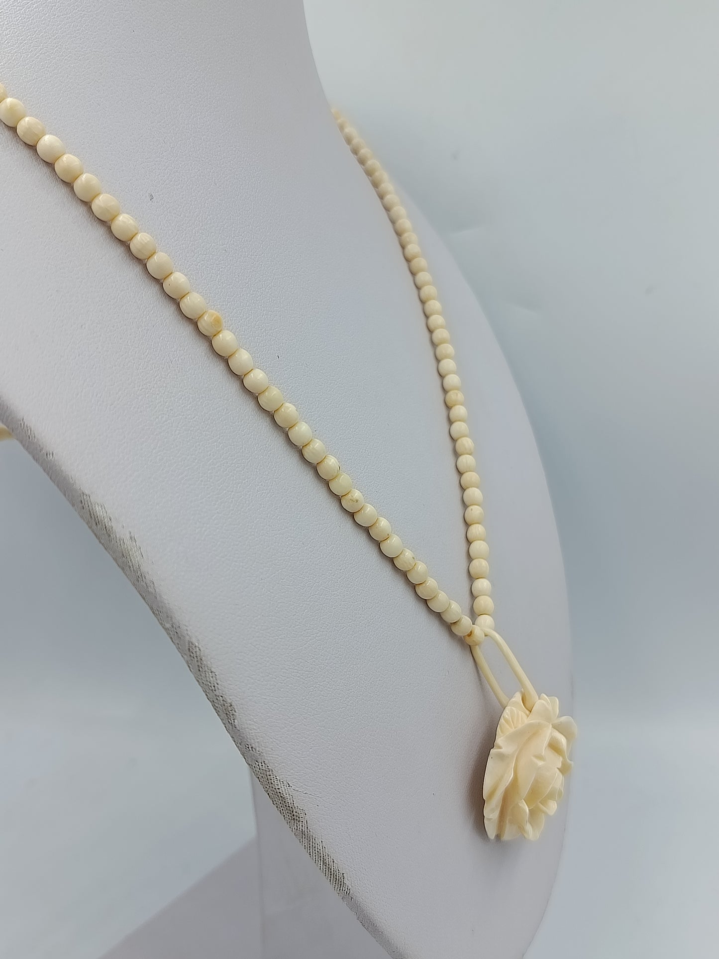 Elegante Kette in Cremeoptik mit fein geschnitzter Blütenform als stilvoller Blickfang