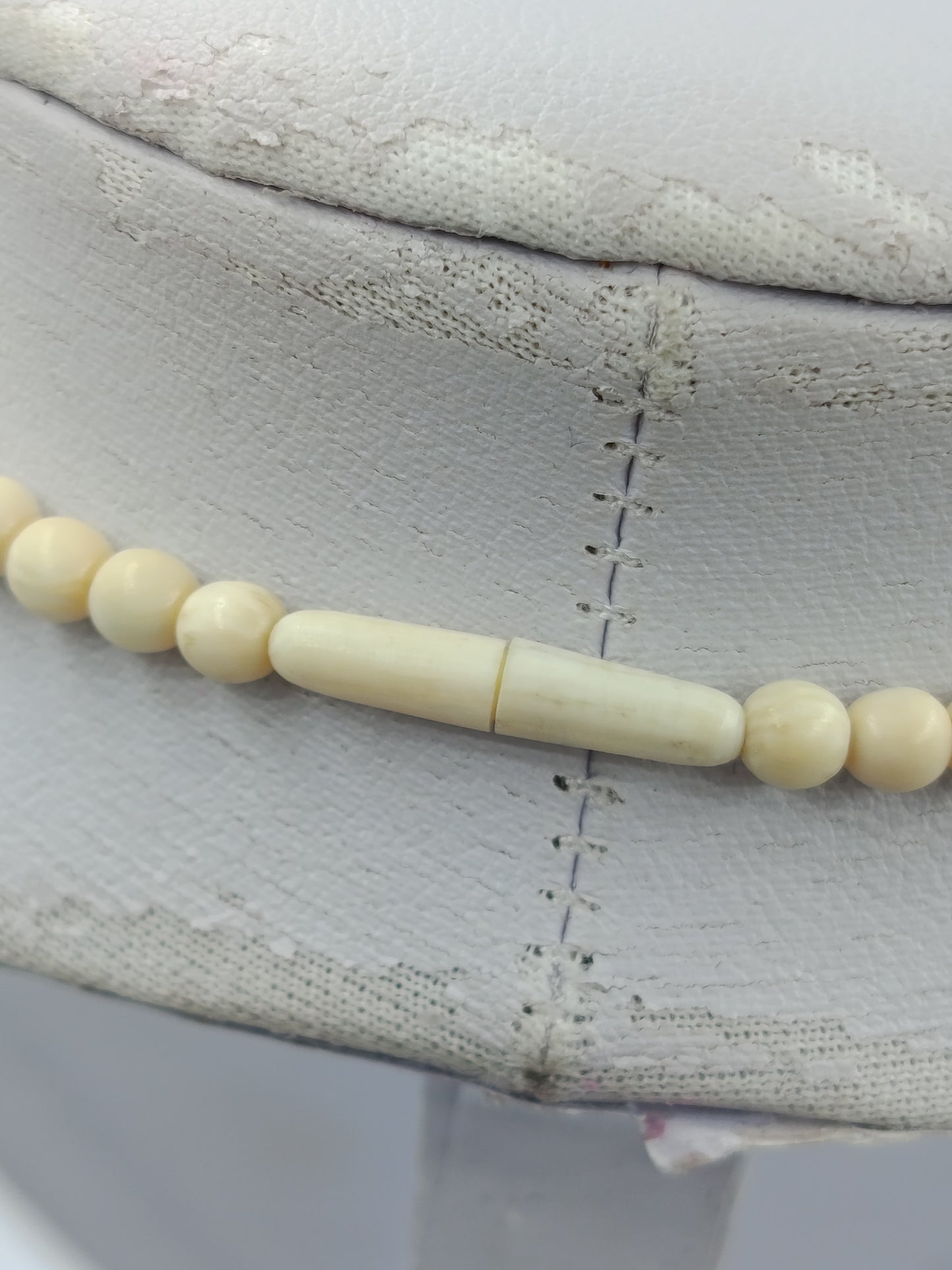 Elegante Kette in Cremeoptik mit fein geschnitzter Blütenform als stilvoller Blickfang