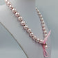 Elegante Perlenkette in zartem Rosé mit Schleifenband und Charm Anhänger
