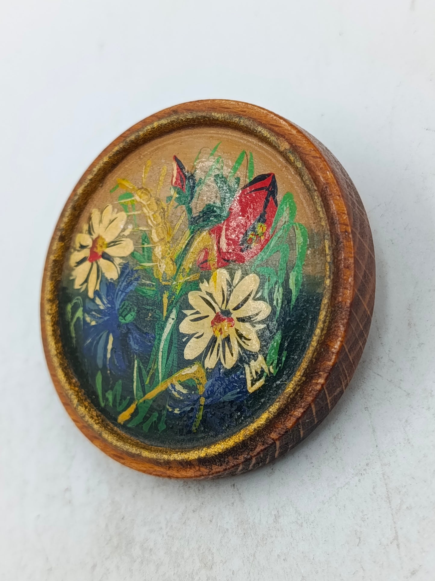 Runde Holz Brosche mit handgemaltem Blumenmotiv in warmen Naturfarben