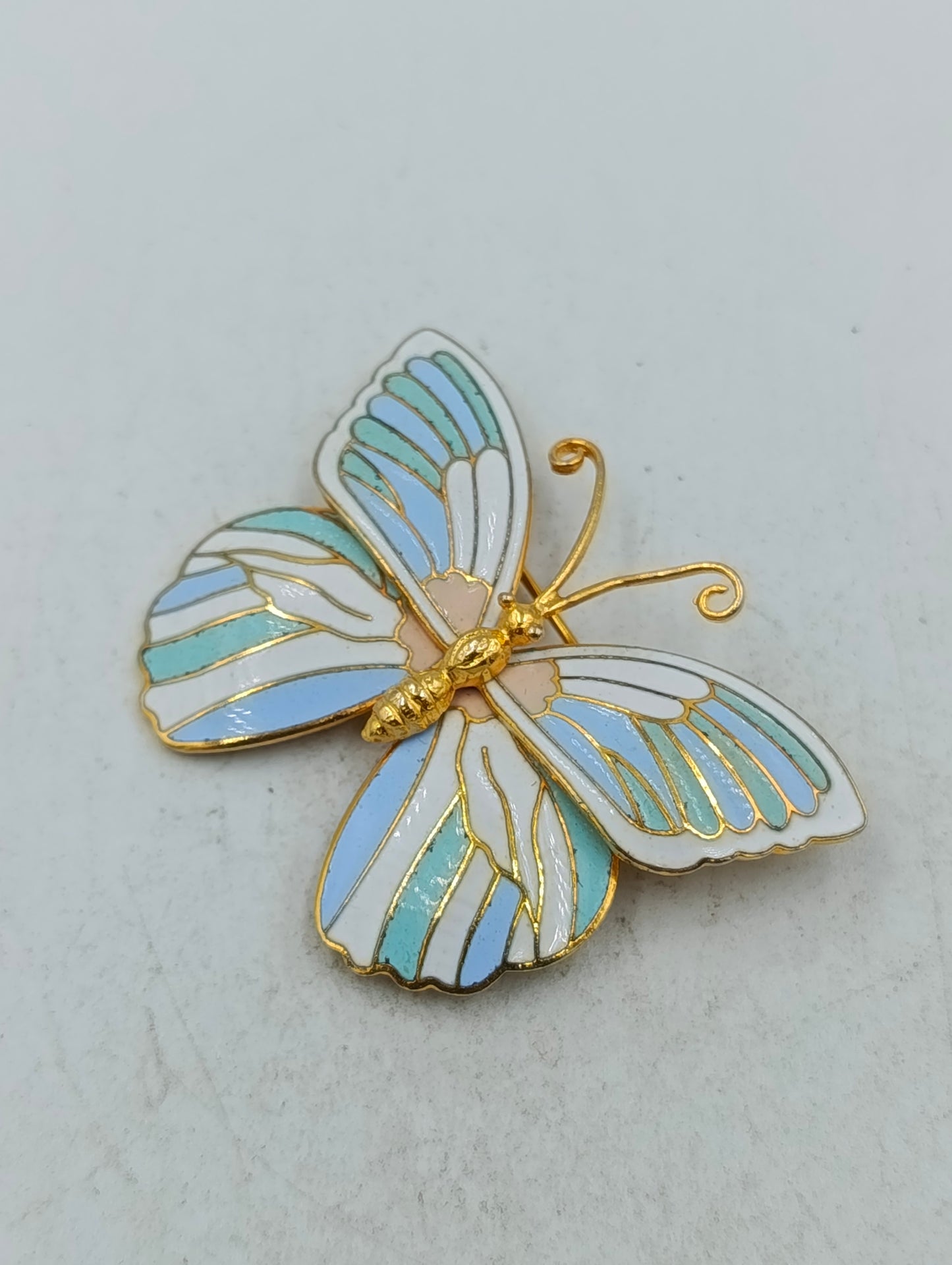 Emaille Schmetterlingsbrosche in Goldoptik mit pastellfarbenem Flügeldesign