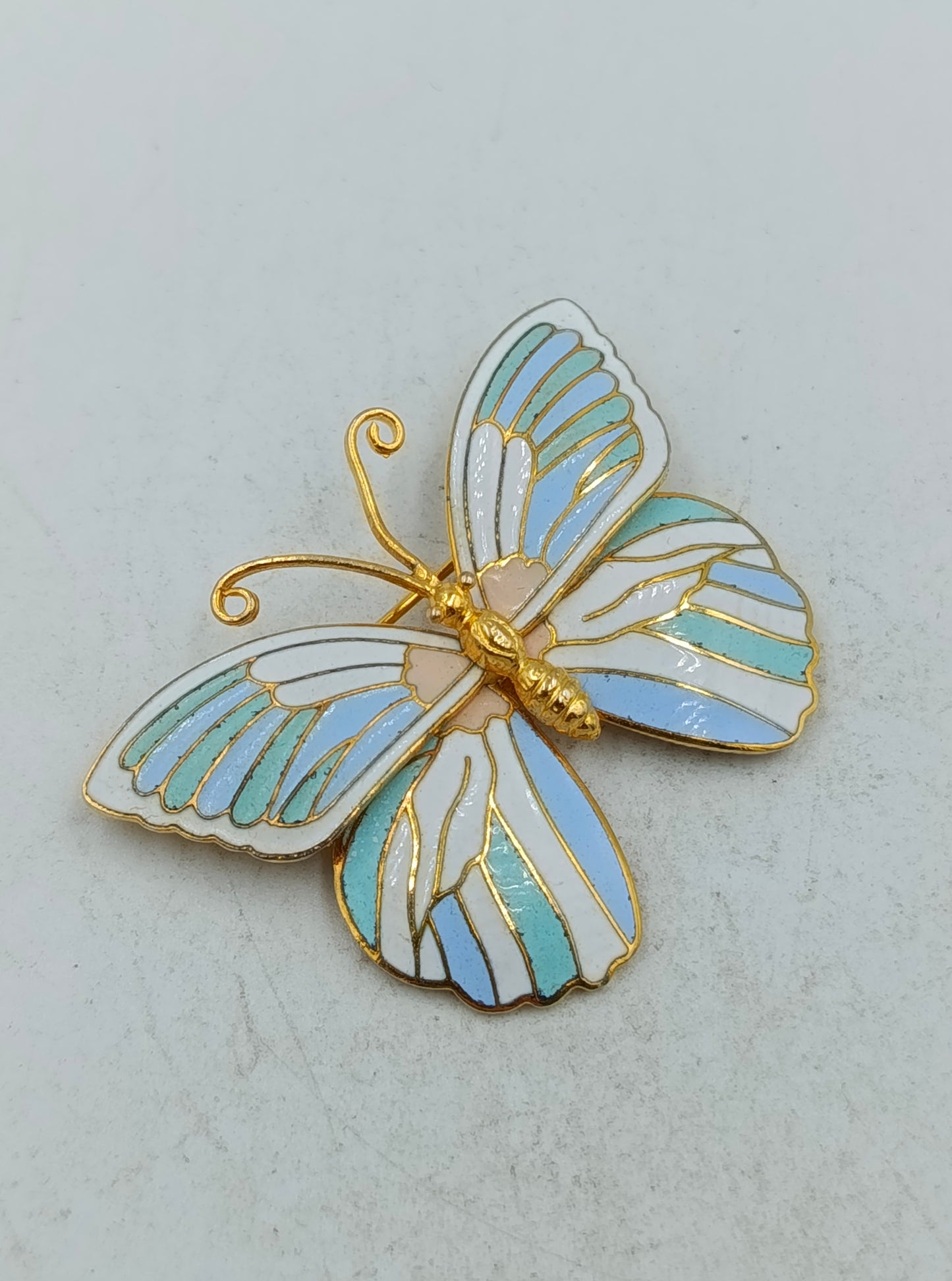 Emaille Schmetterlingsbrosche in Goldoptik mit pastellfarbenem Flügeldesign