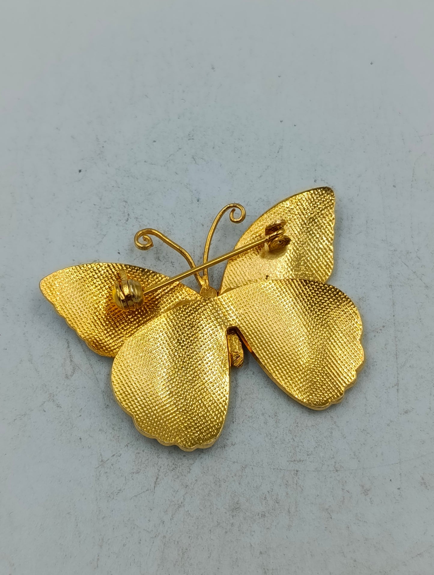 Emaille Schmetterlingsbrosche in Goldoptik mit pastellfarbenem Flügeldesign