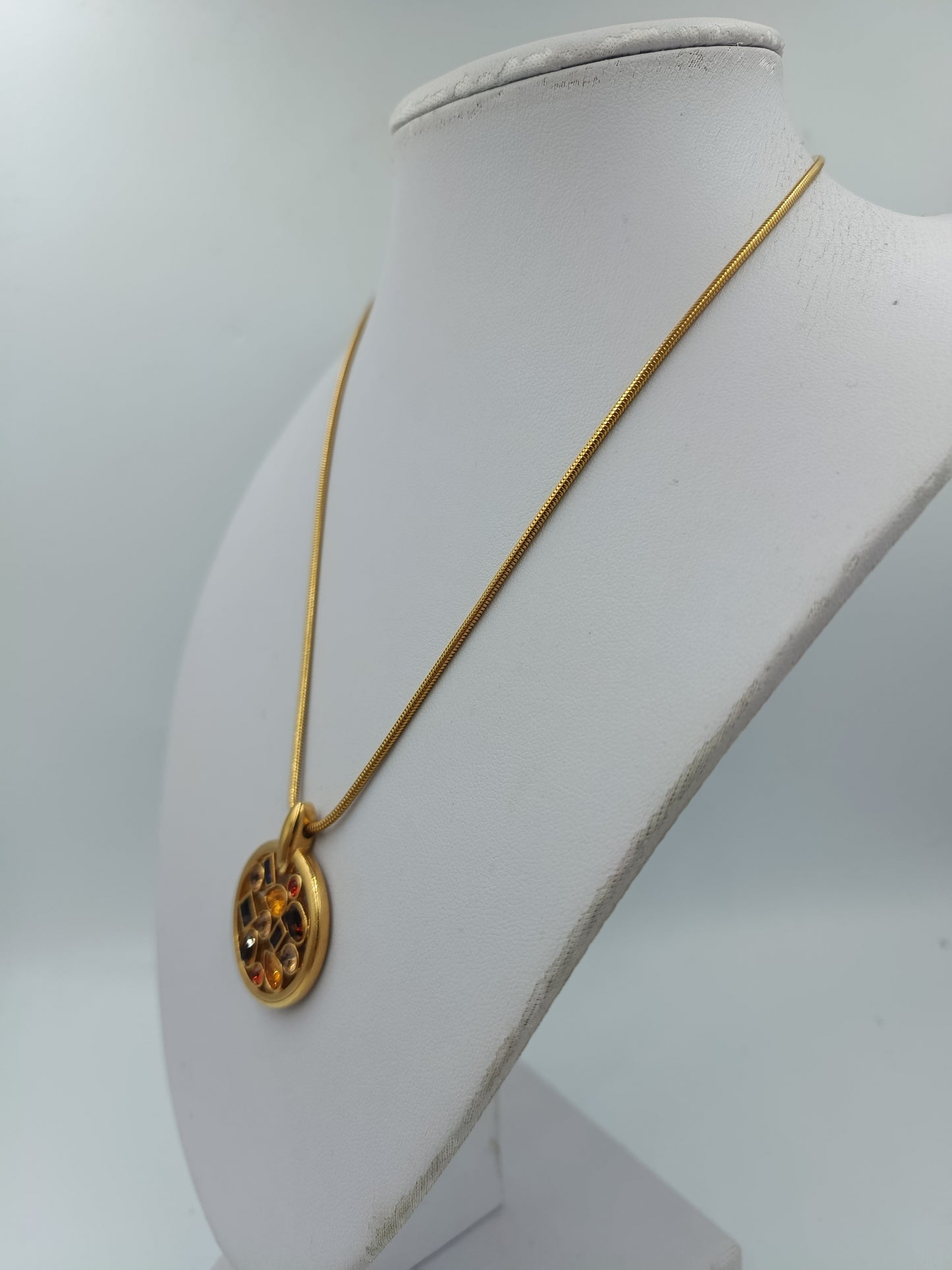 Goldfarbene Halskette mit rundem Anhänger und funkelnden Swarovski Steinen