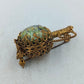 Goldfarbene Brosche mit runder Steinoptik und kunstvollem Vintage Design