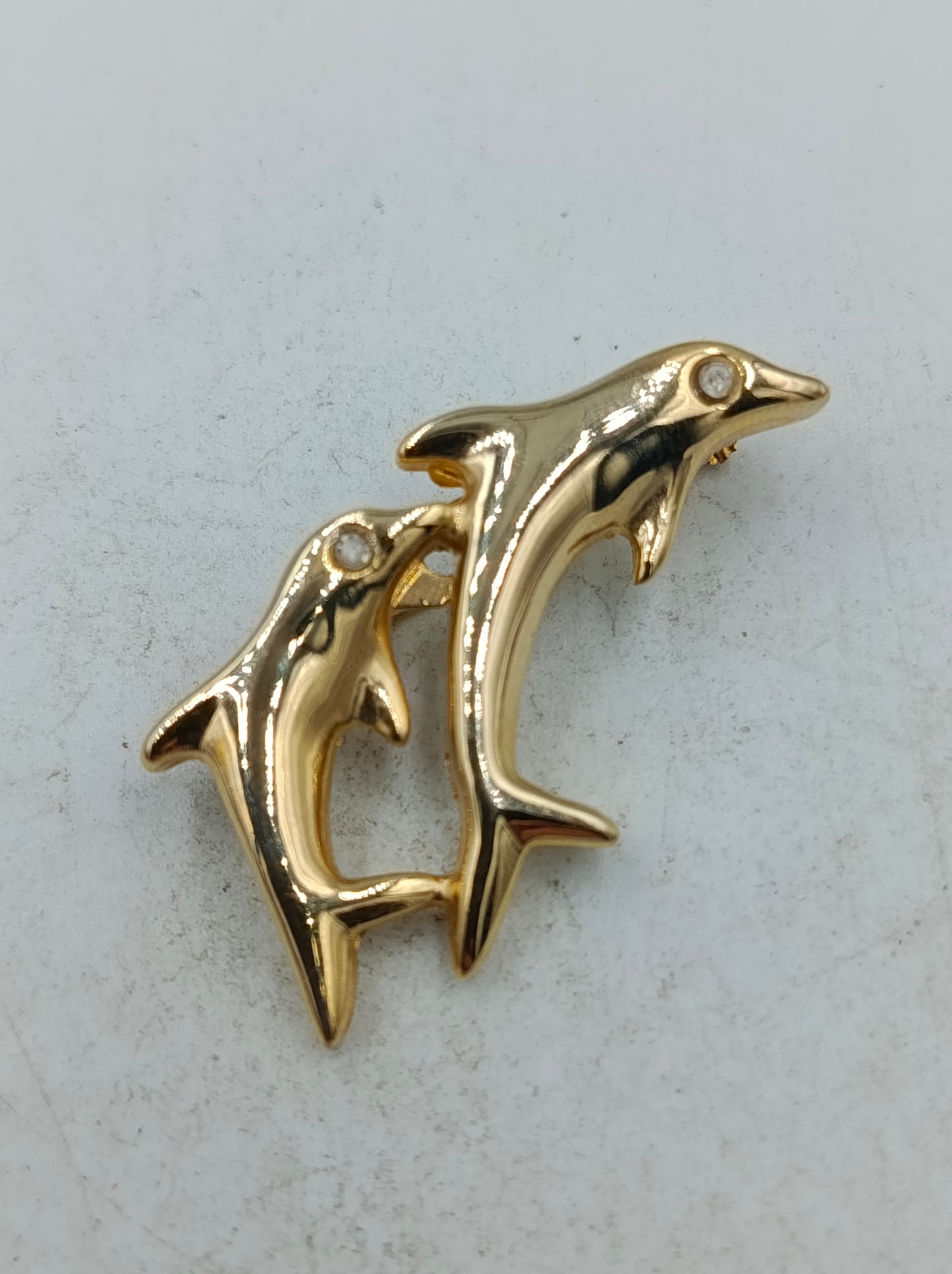 Goldfarbene Brosche mit zwei springenden Delfinen in elegantem maritimem Design